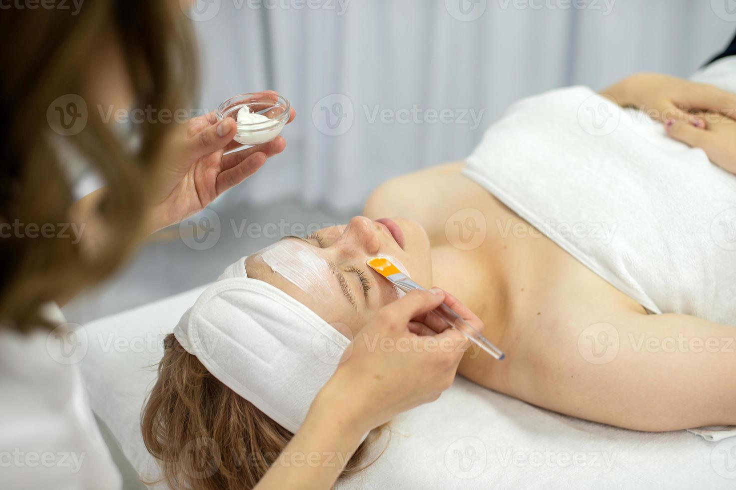 Cosmetic procedure, apply the mask on the face with a brush photo