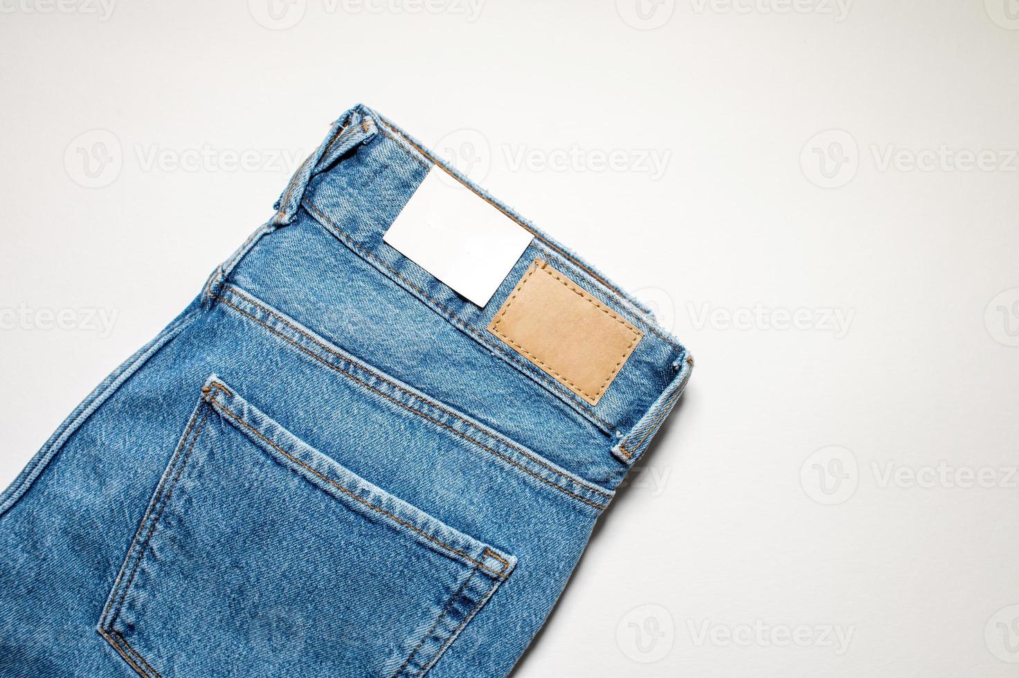 A pair of denim trousers with an empty leather label . photo