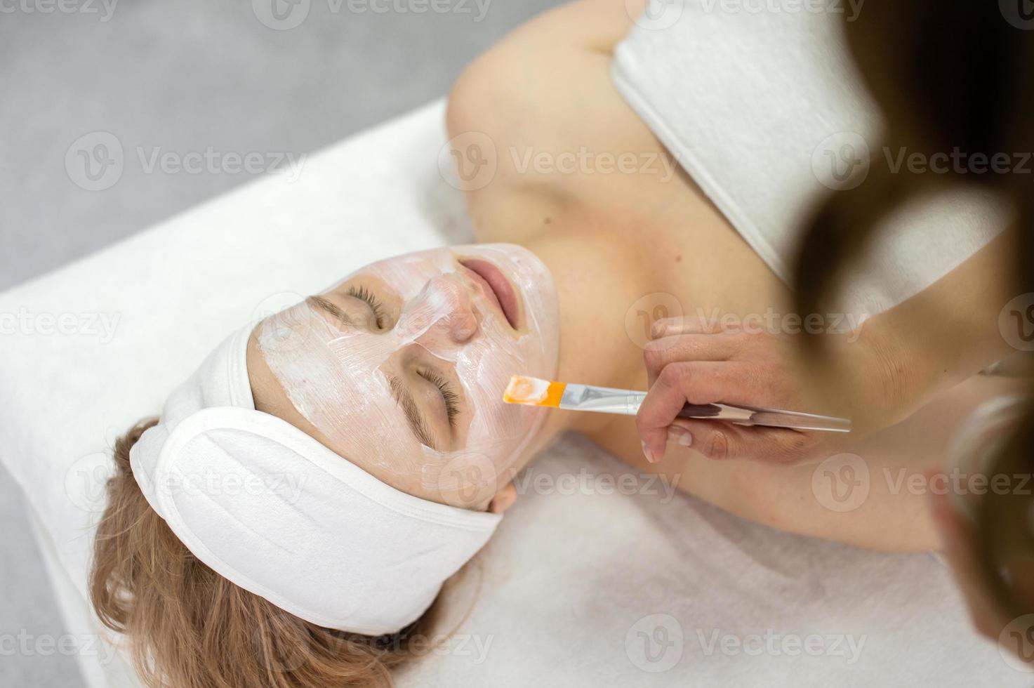 Cosmetic procedure, apply the mask on the face with a brush photo