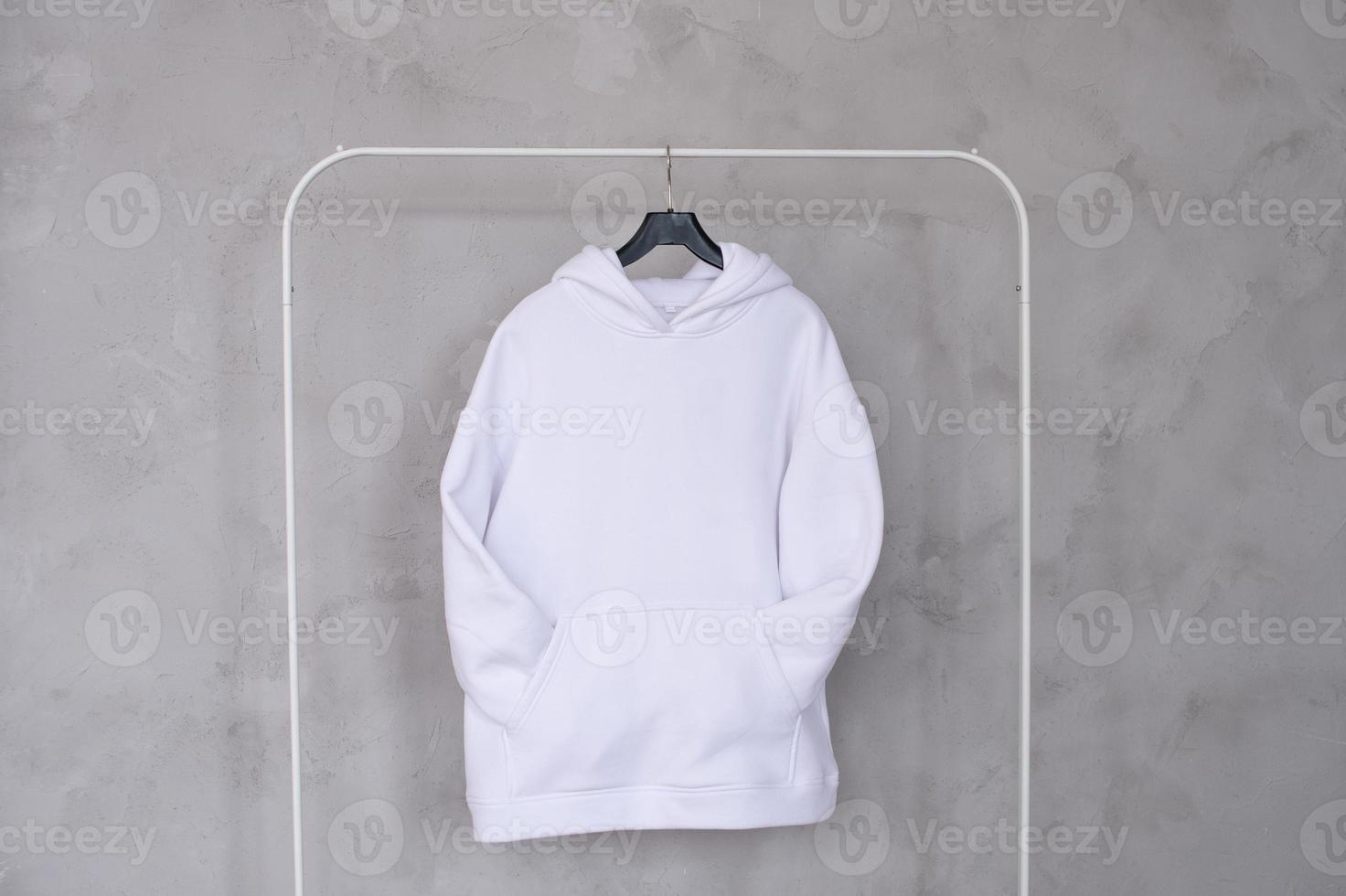 A set of mockups of a white hoodie with a hood and a pocket hanging on a hanger photo