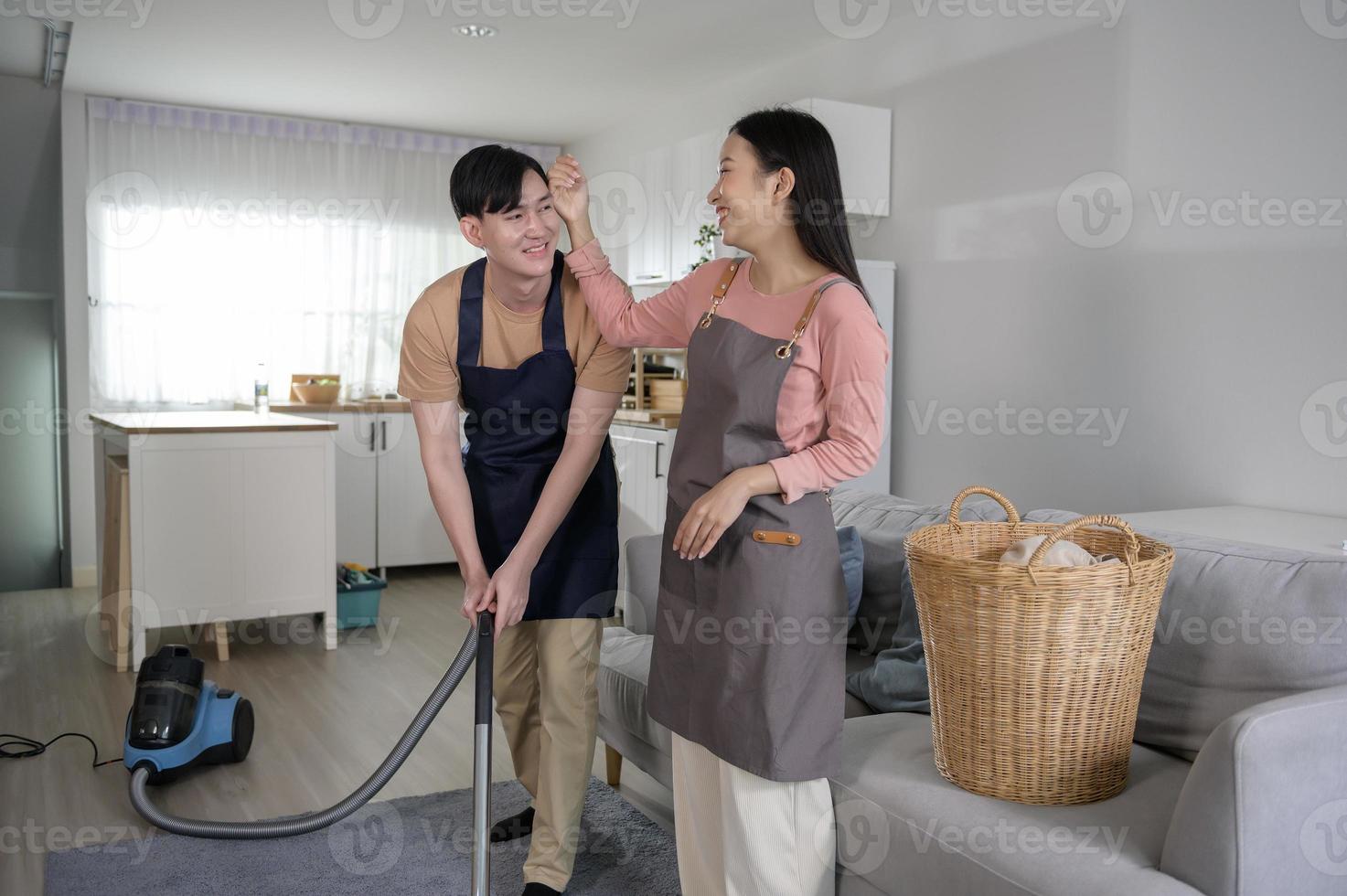 Happy young Asian couple cleaning home together, healthy lifestyle concept photo