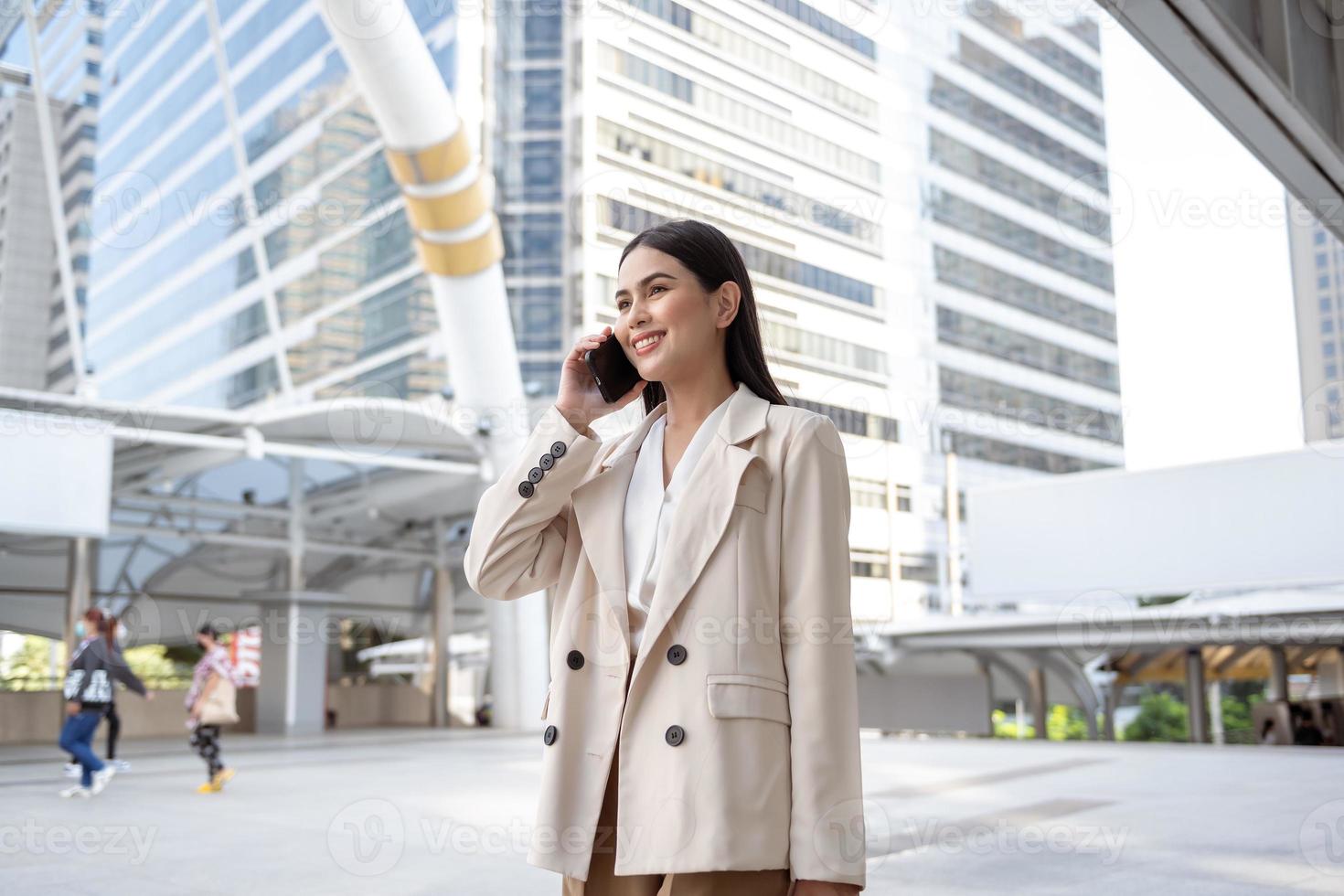 retrato de joven hermosa mujer de negocios utilizando teléfono inteligente en moderno ciudad foto