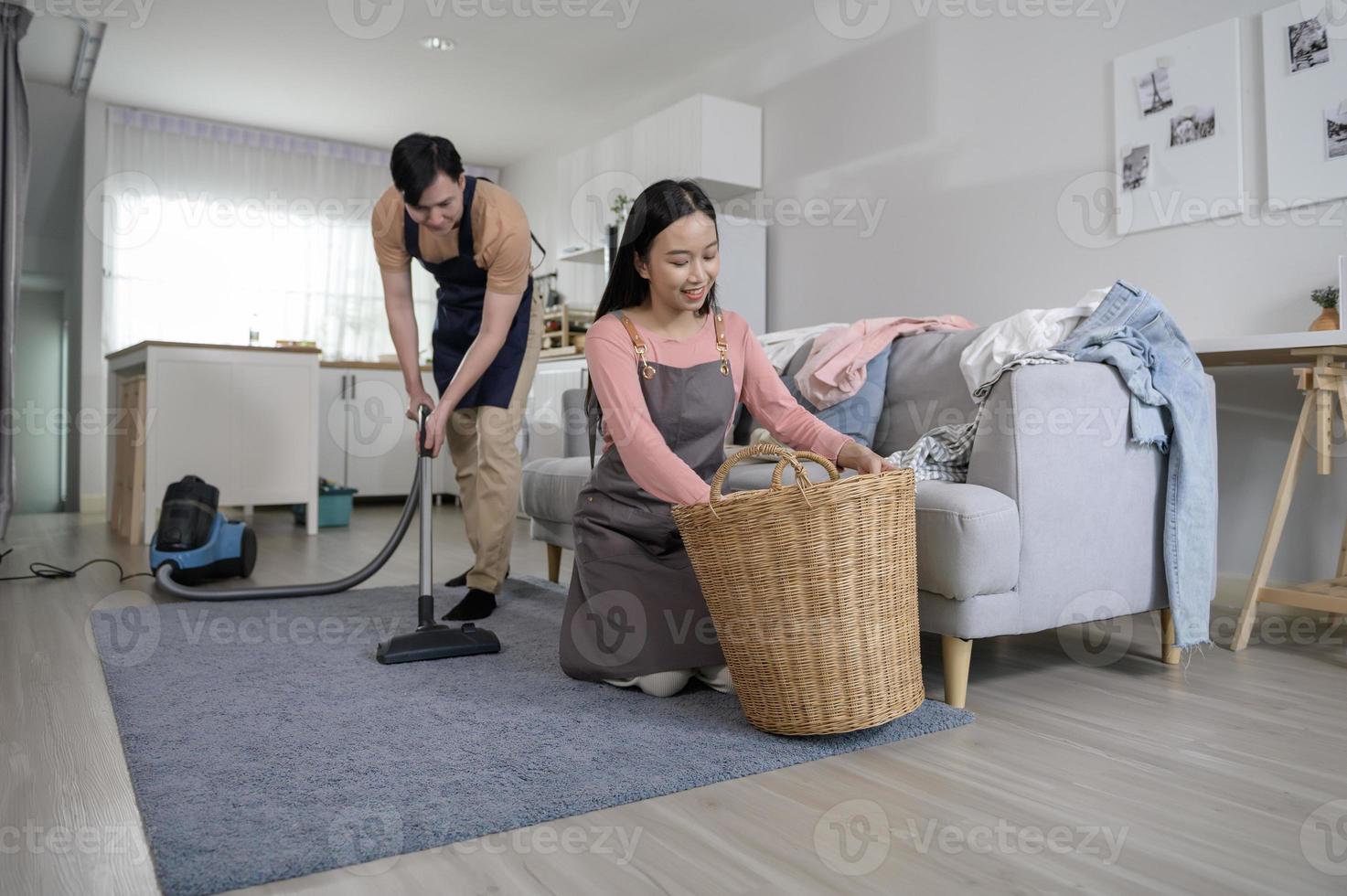 Happy young Asian couple cleaning home together, healthy lifestyle concept photo