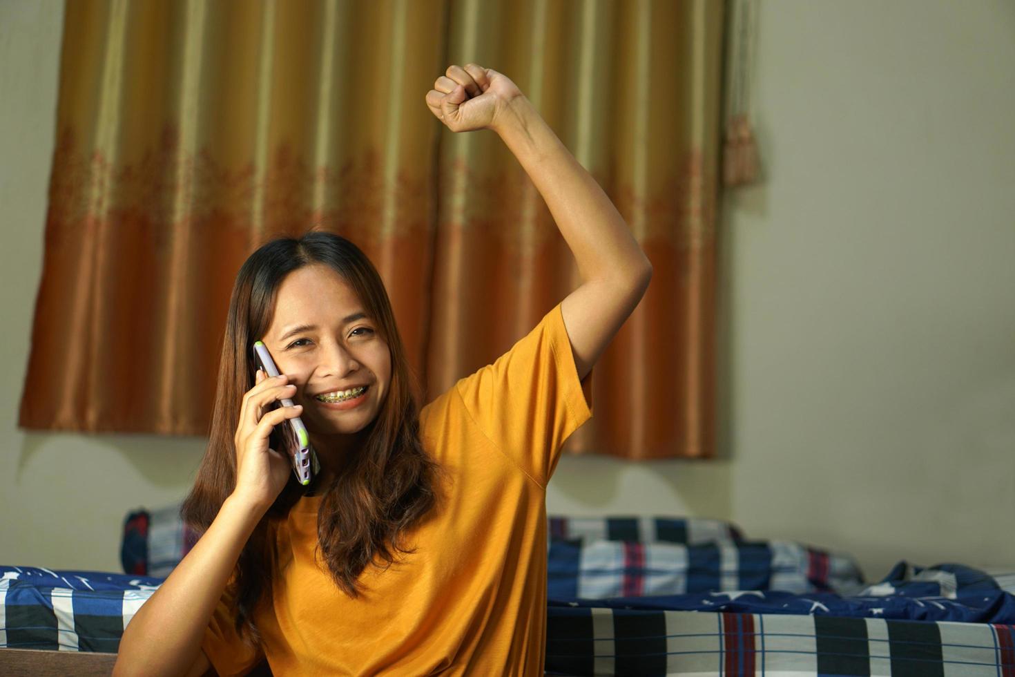 contento asiático mujer mirando a el teléfono, conocimiento ese ganancias son más alto, trabajo desde hogar. foto