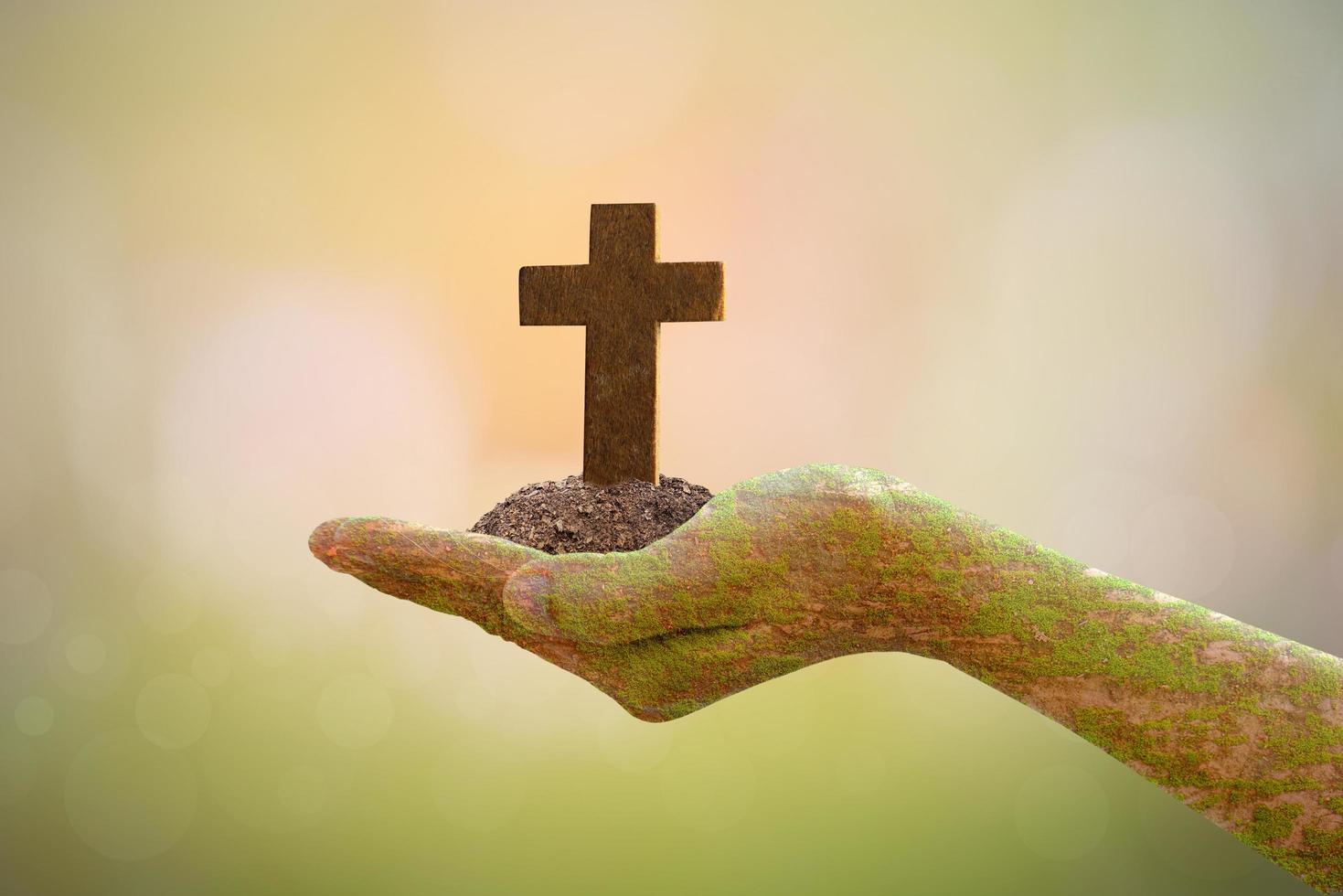 Human hand holding cross on blurred nature background. photo