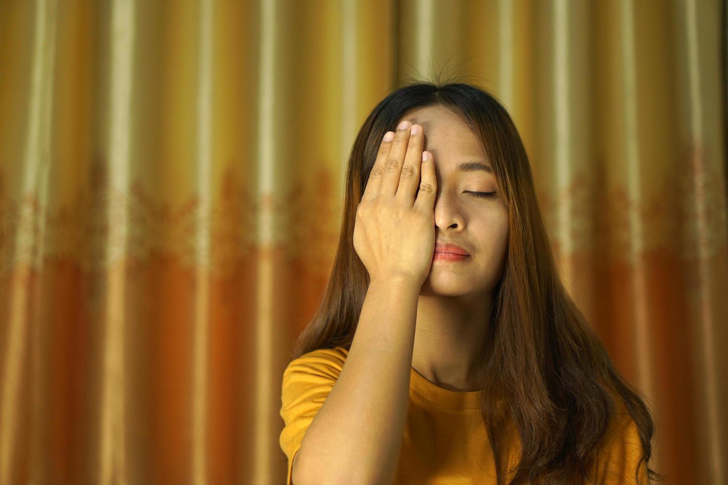 Asian woman lying on the bed, having eye pain photo