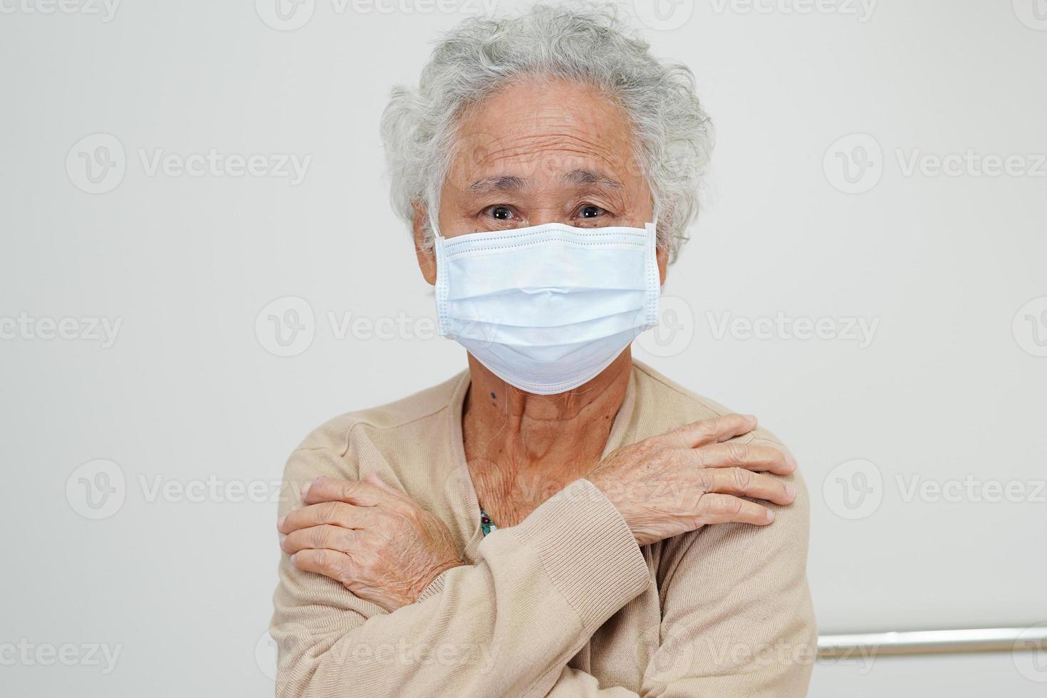 Asian elderly woman patient wearing a mask for protect Covid-19 Coronavirus. photo