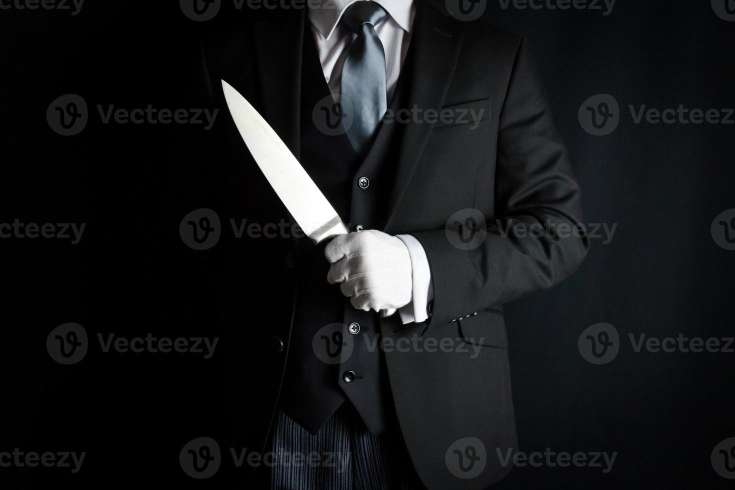 Portrait of Butler in Dark Suit and White Gloves Holding Sharp Knife. Concept of The Butler Did It. photo