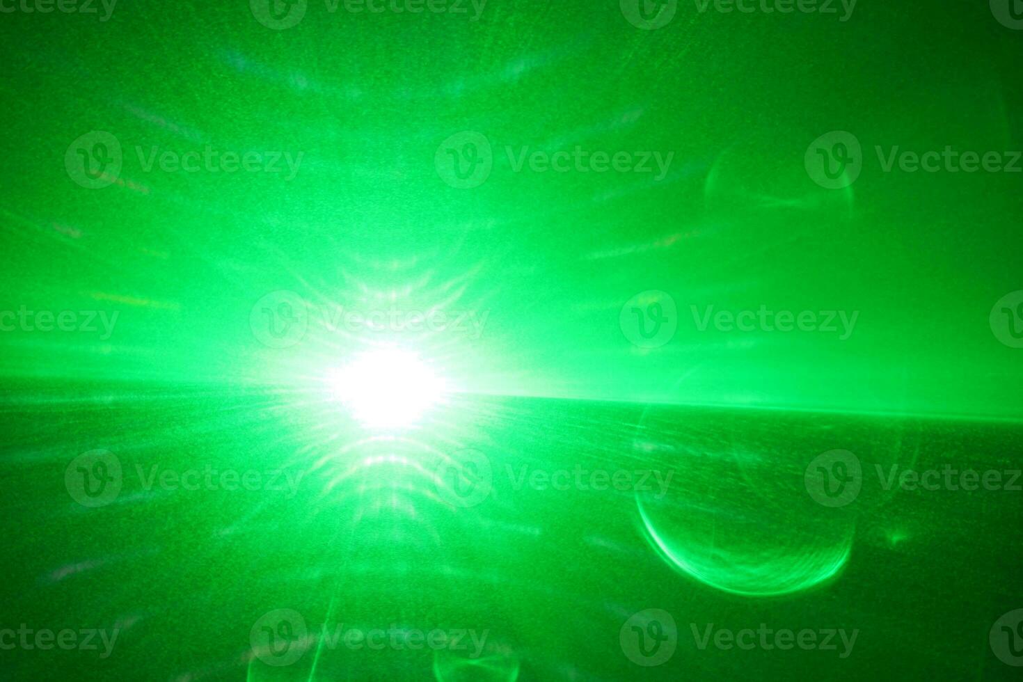 green beam laser beam on dark background photo