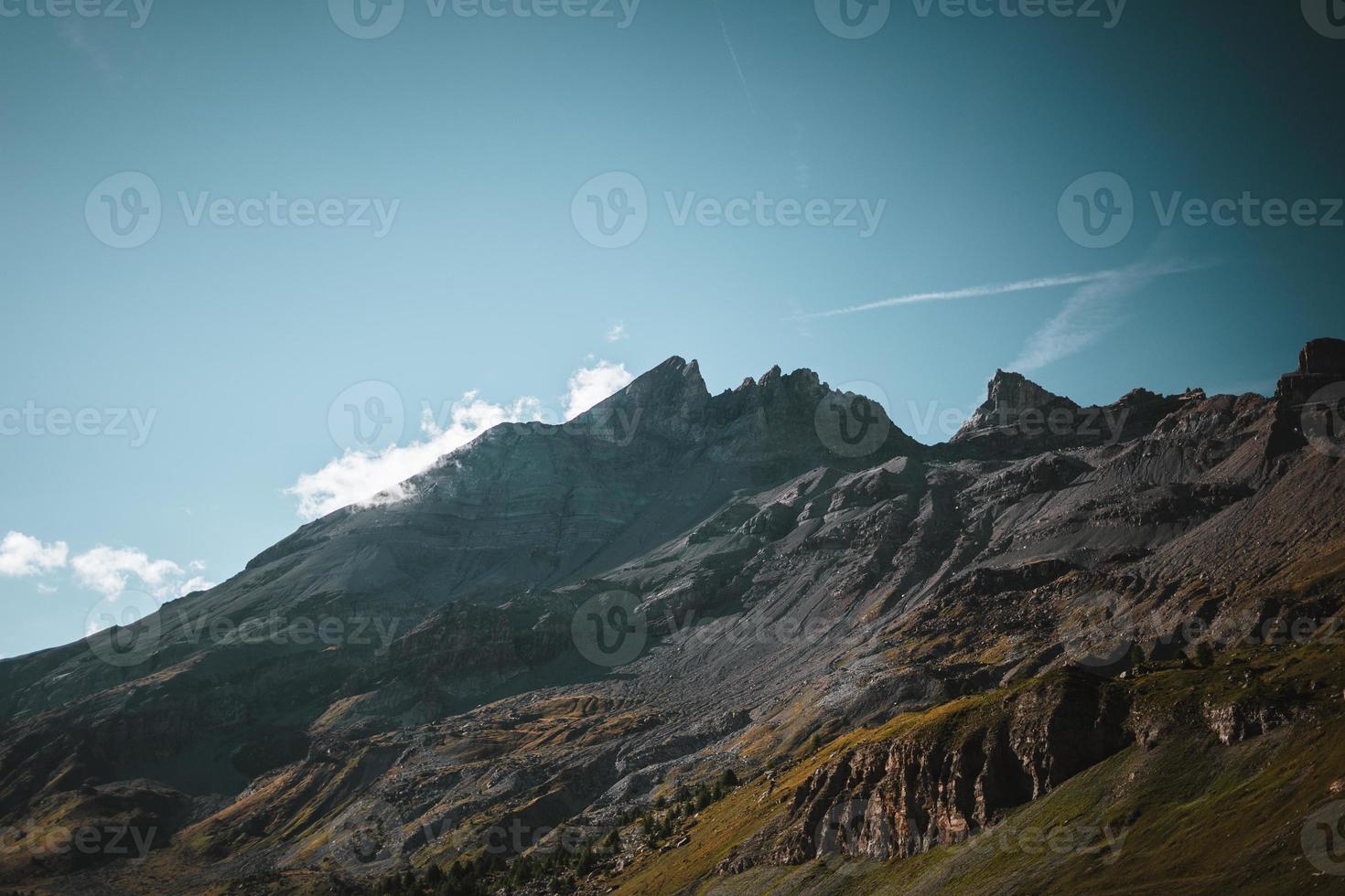 majestuoso montañas en el Alpes cubierto con arboles y nubes foto