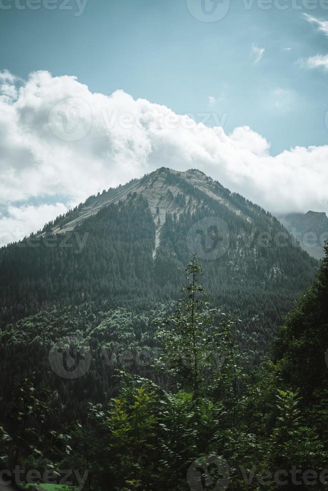 Majestic mountains in the Alps covered with trees and clouds photo