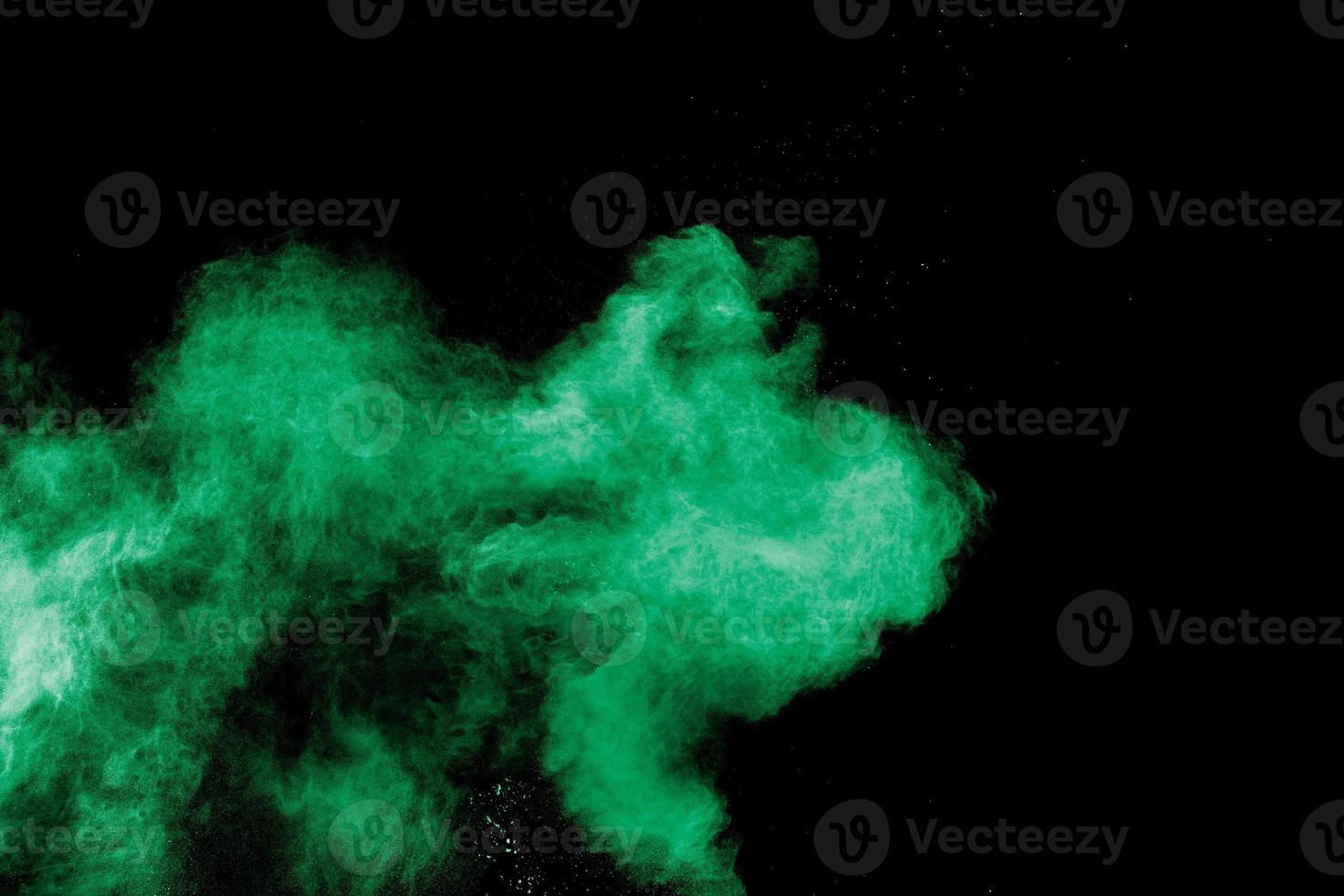 Green color powder explosion cloud on black background.Green dust splash. photo