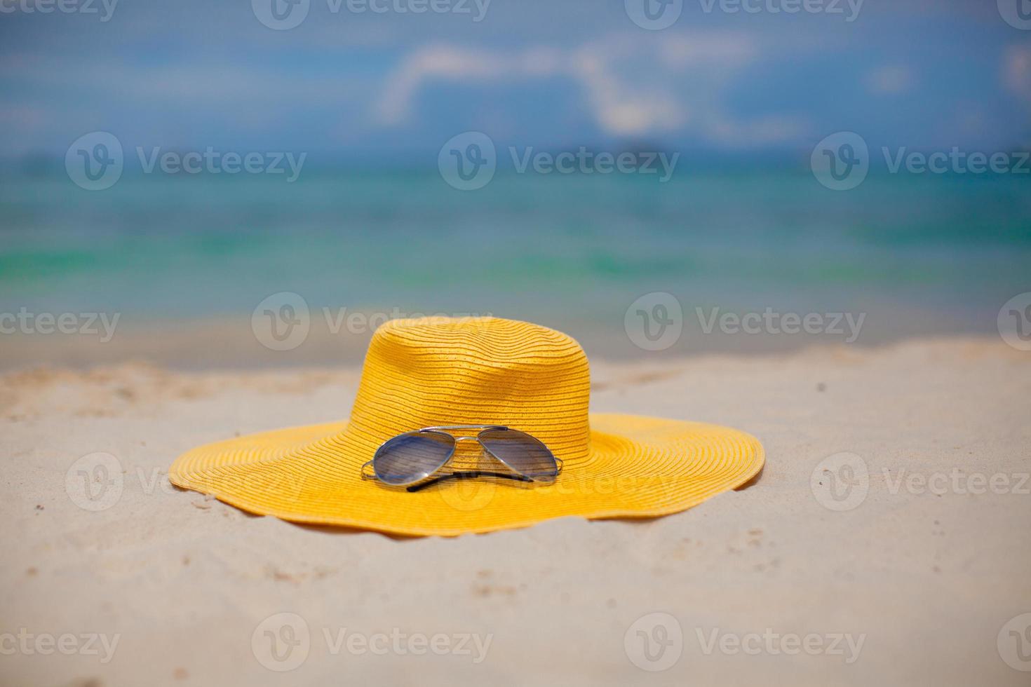 Hat and sunglasses on the beach photo