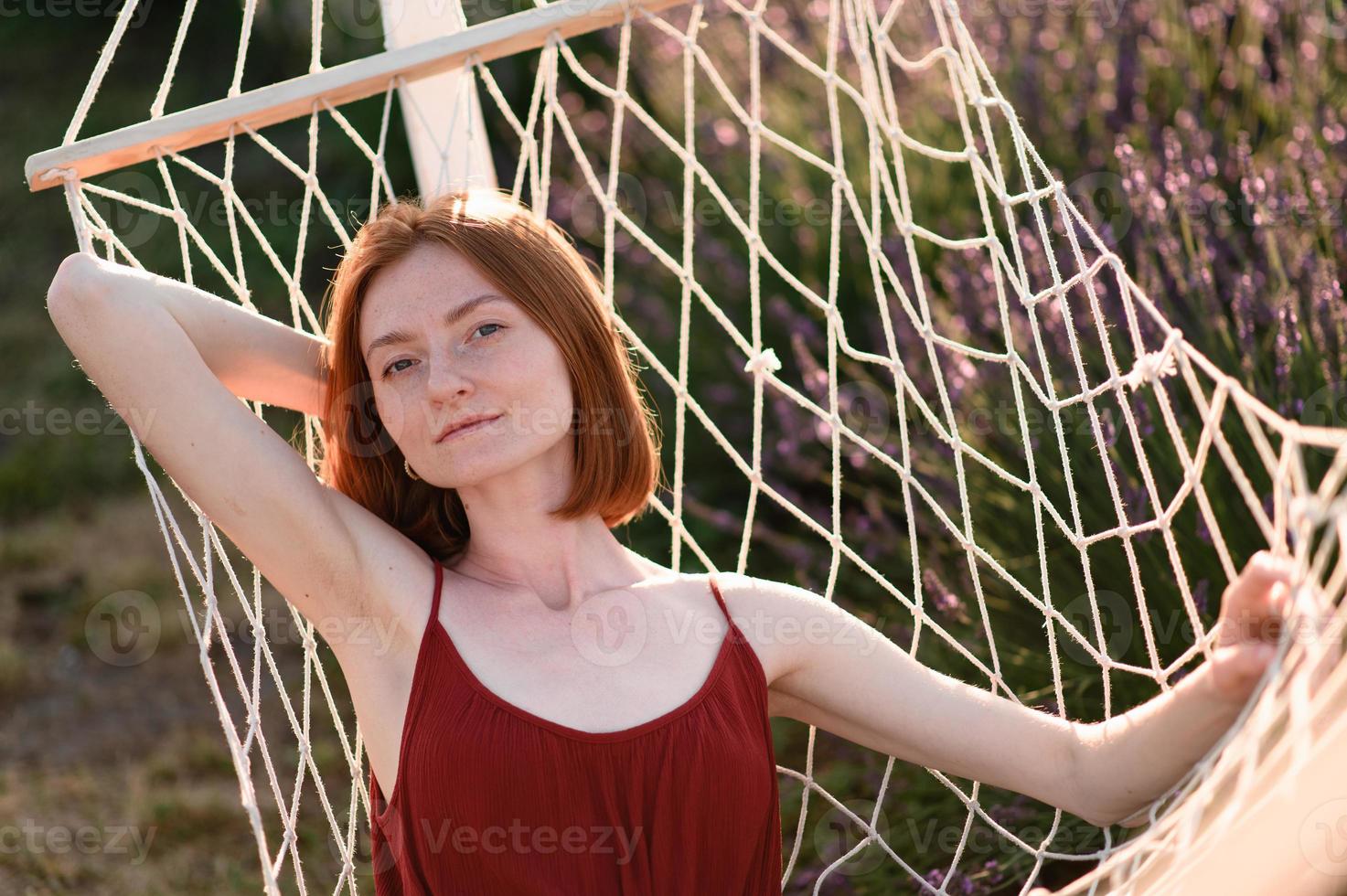 un Pelirrojo joven niña sin maquillaje es descansando en un lavanda campo. verano vacaciones y viaje tiempo. foto