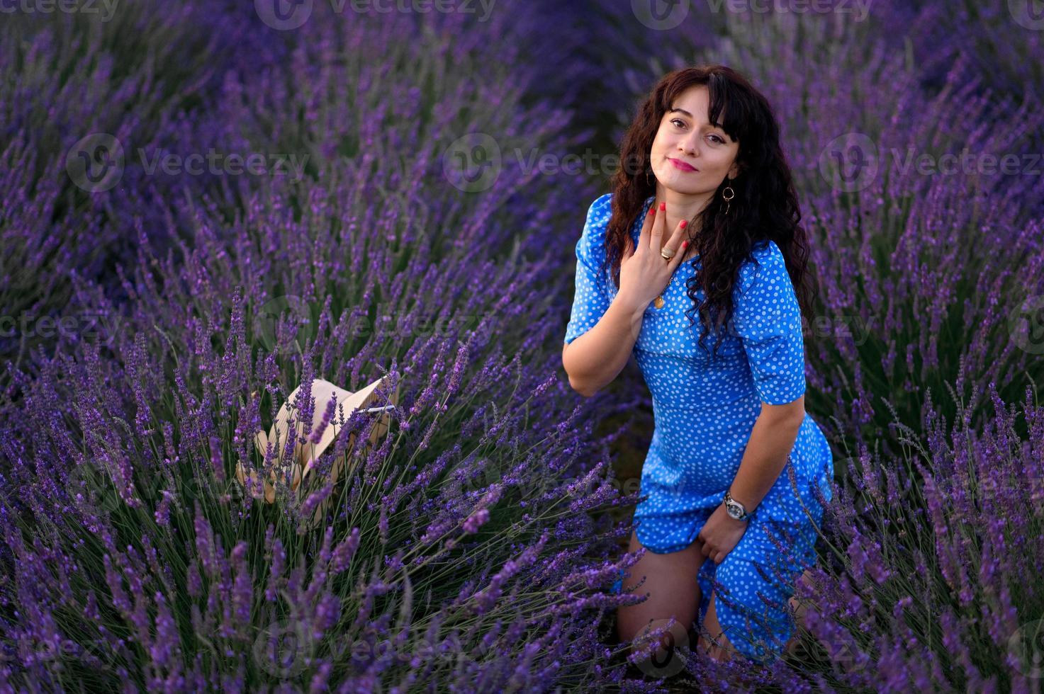 Portrait of a happy woman in a blue dress enjoying a sunny summer day in a lavender field. Fresh air, Lifestyle. photo