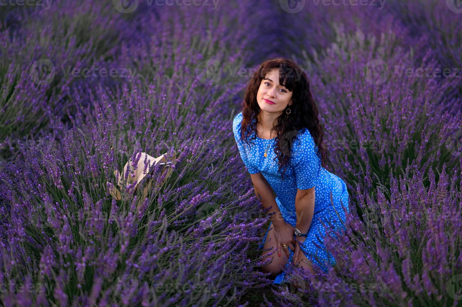 Portrait of a happy woman in a blue dress enjoying a sunny summer day in a lavender field. Fresh air, Lifestyle. photo