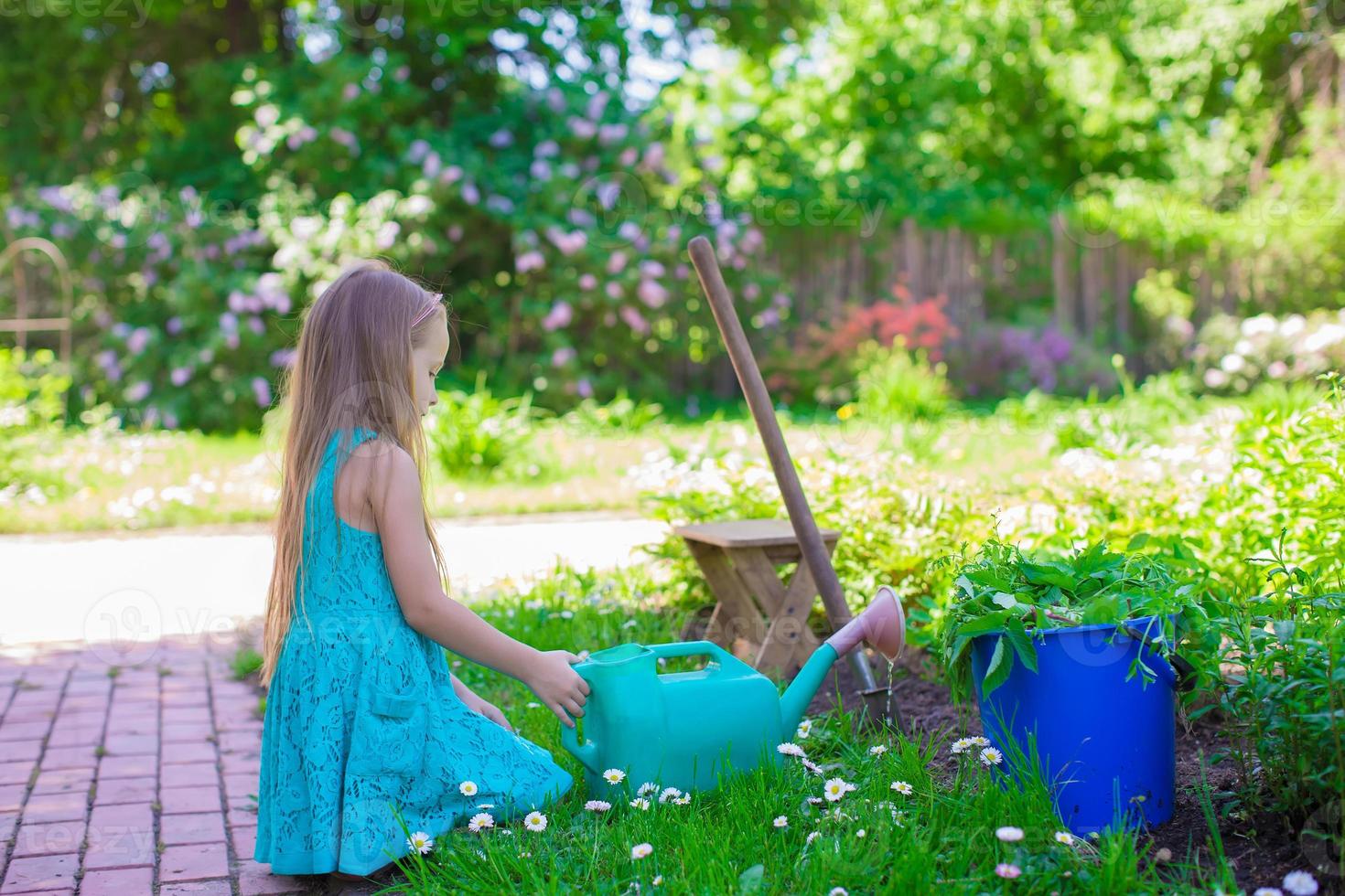 Little girl with flowers in the garden photo