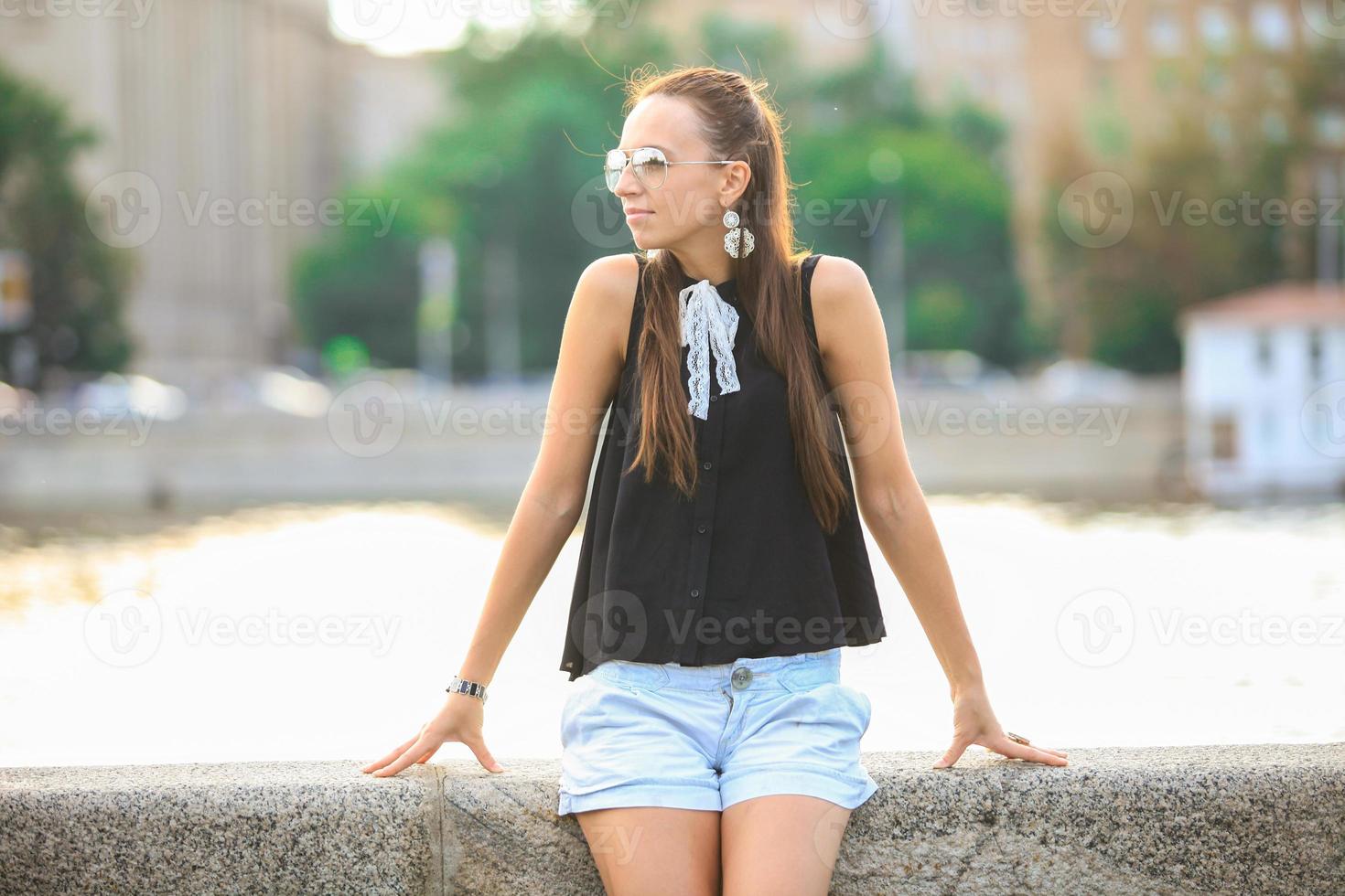 Woman sitting by a bridge photo