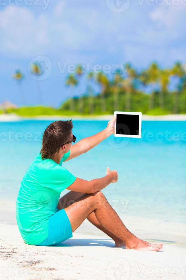 Man with device by the beach photo