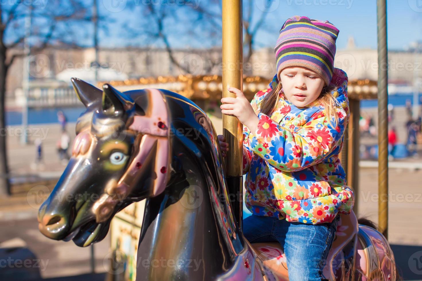 Little girl on a carousel photo