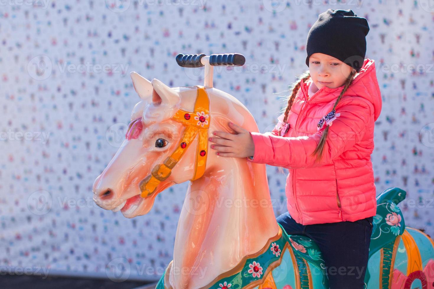 Little girl on a carousel photo