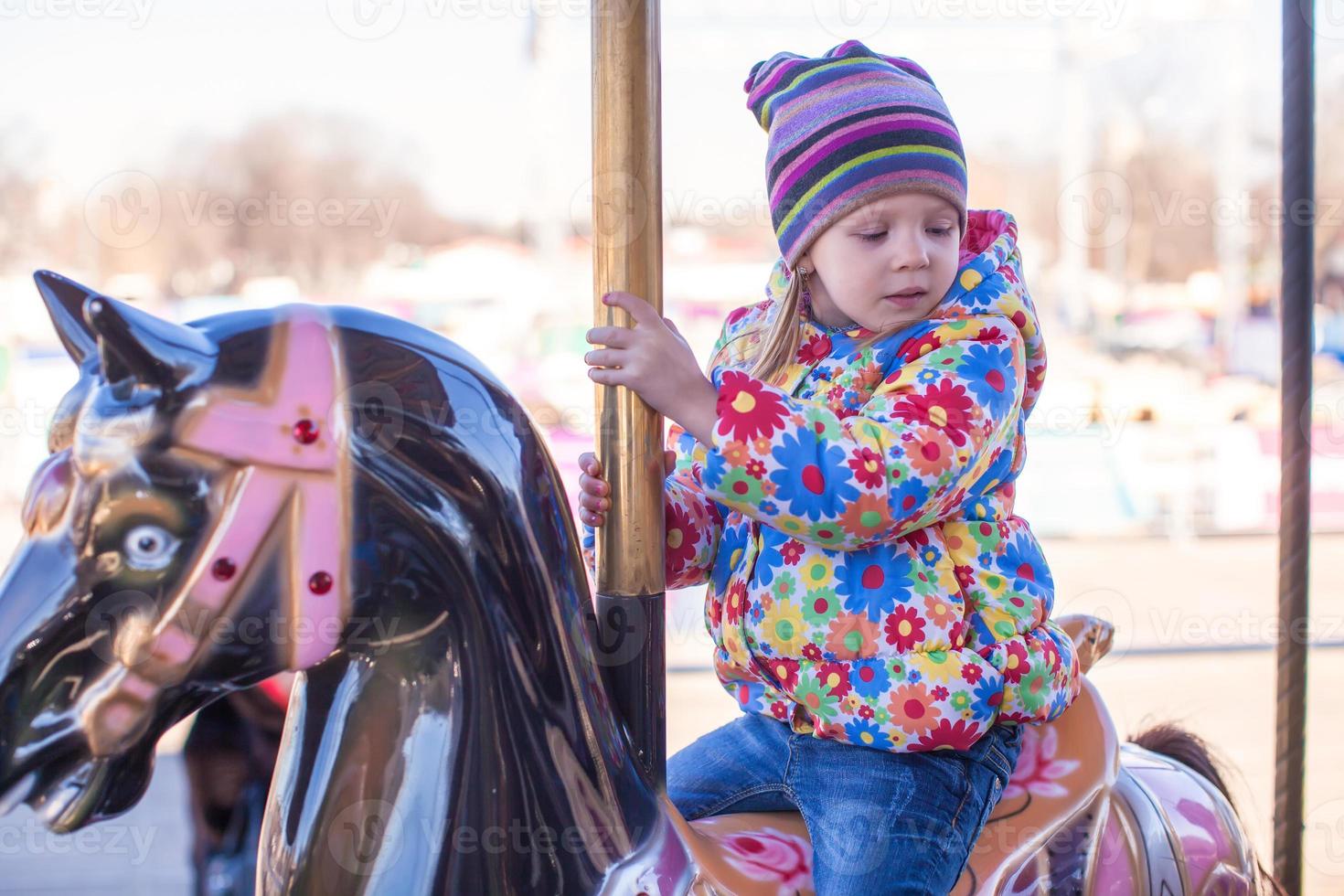 pequeño niña en un carrusel foto