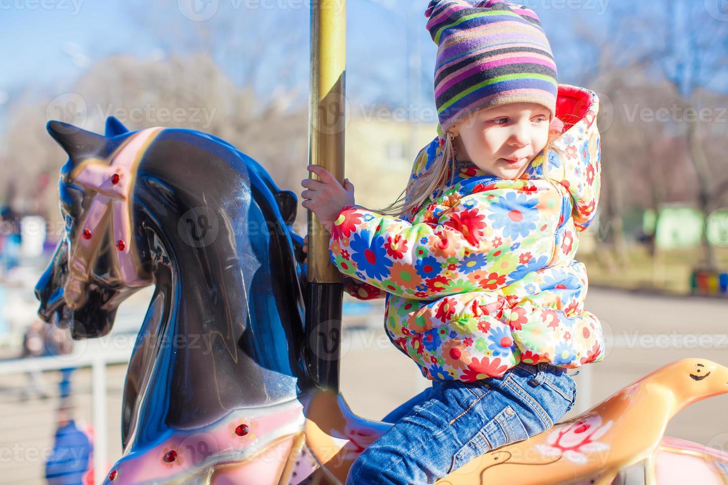 Little girl on a carousel photo