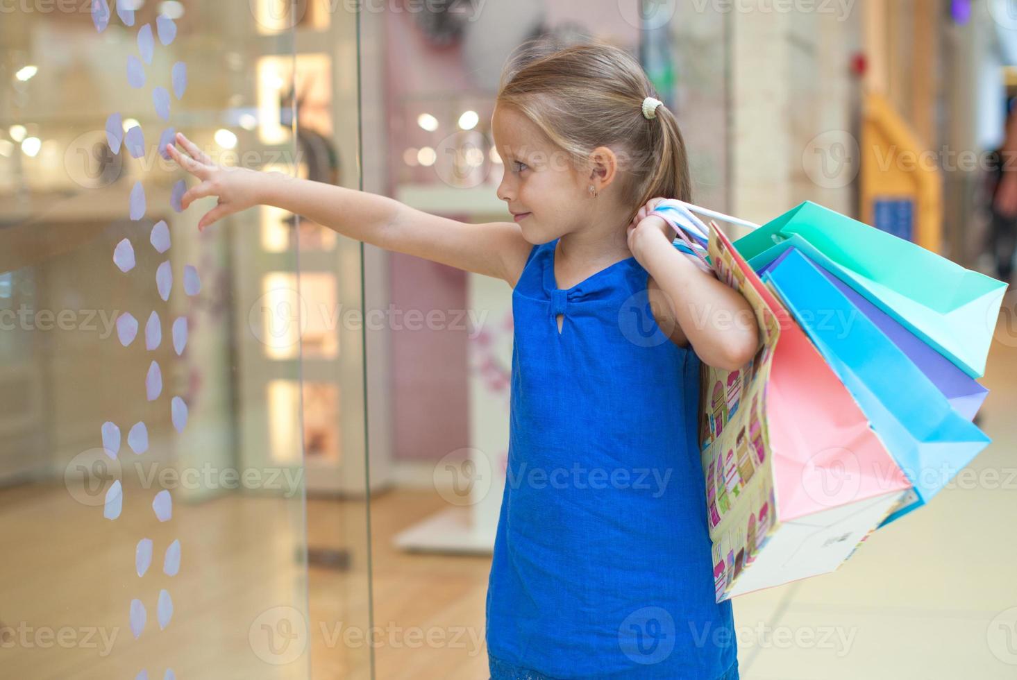 pequeño niña con compras pantalones foto