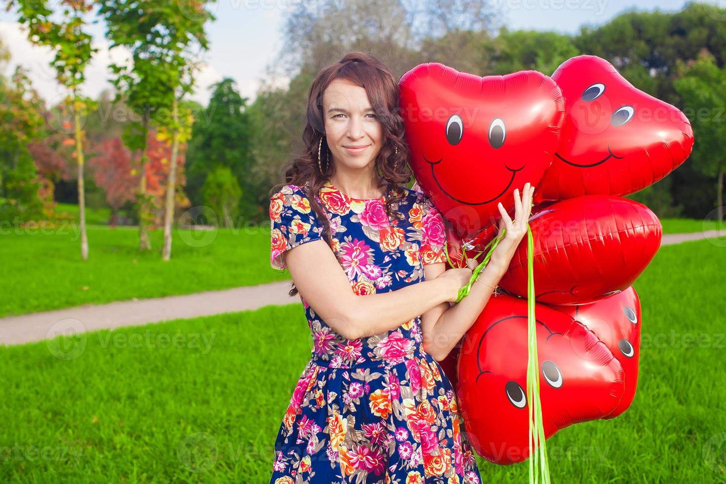 joven mujer con rojo corazón globos foto