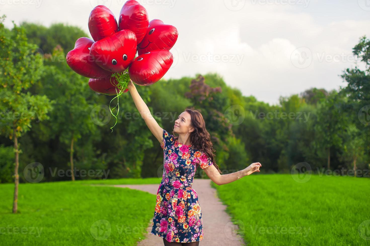 Young woman with red heart balloons photo