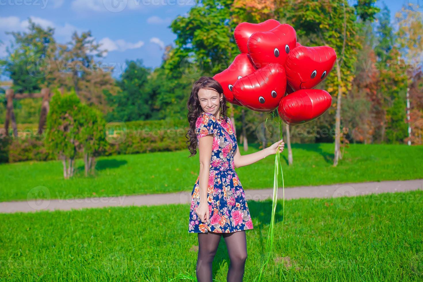 joven mujer con rojo corazón globos foto