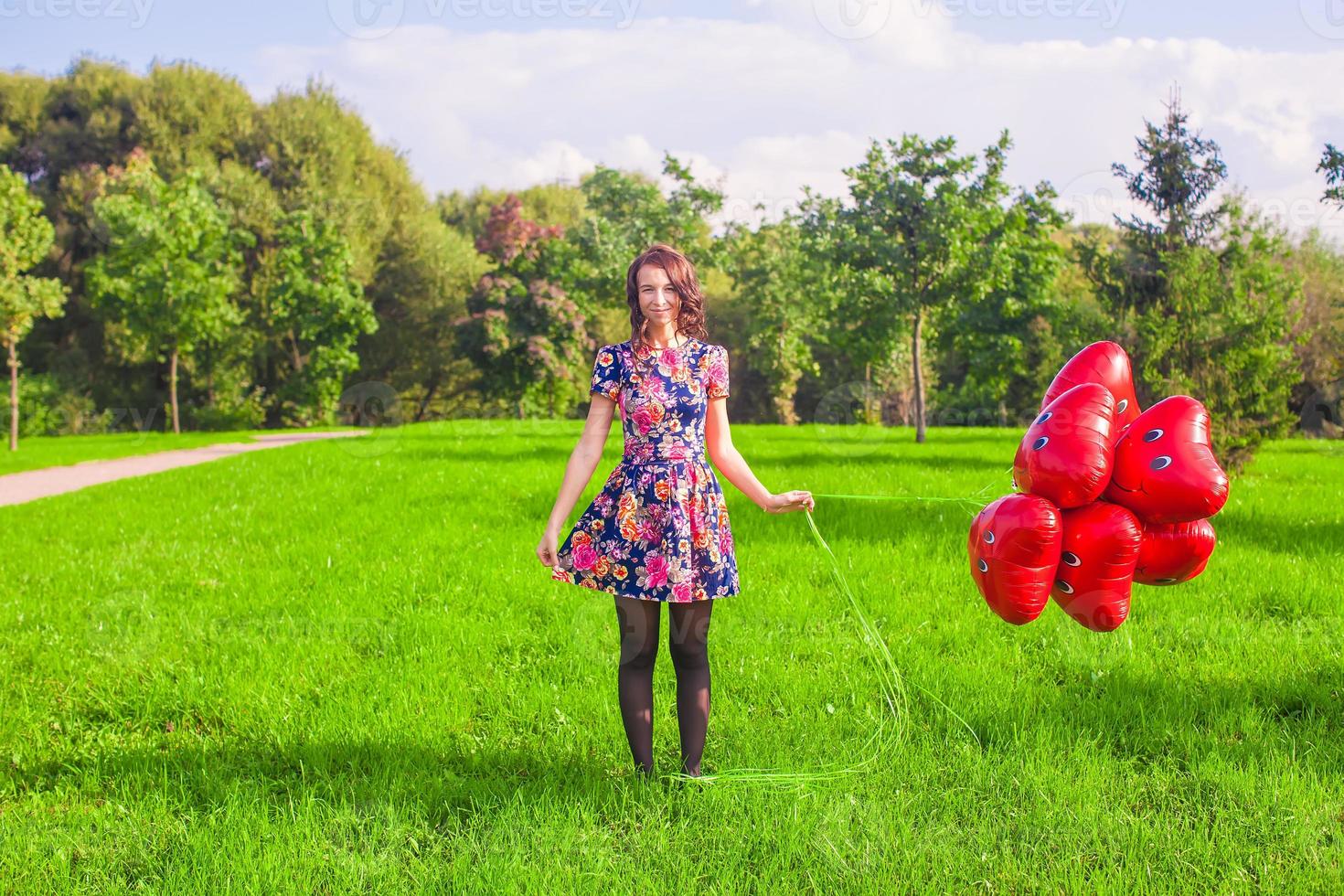 Young woman with red heart balloons photo