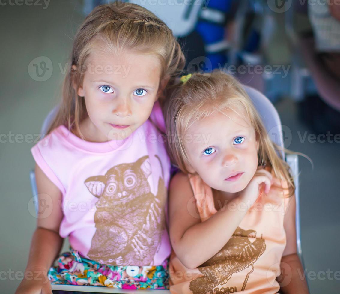 Beautiful little sisters waiting on the airport photo