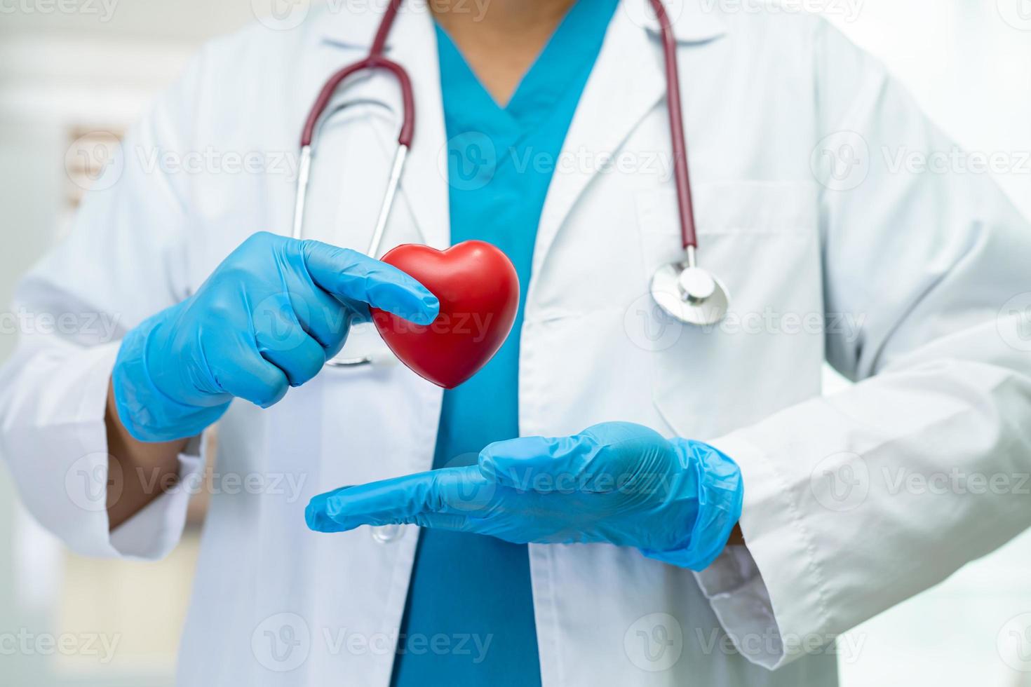 médico sosteniendo un corazón rojo en la sala del hospital, concepto médico fuerte y saludable. foto