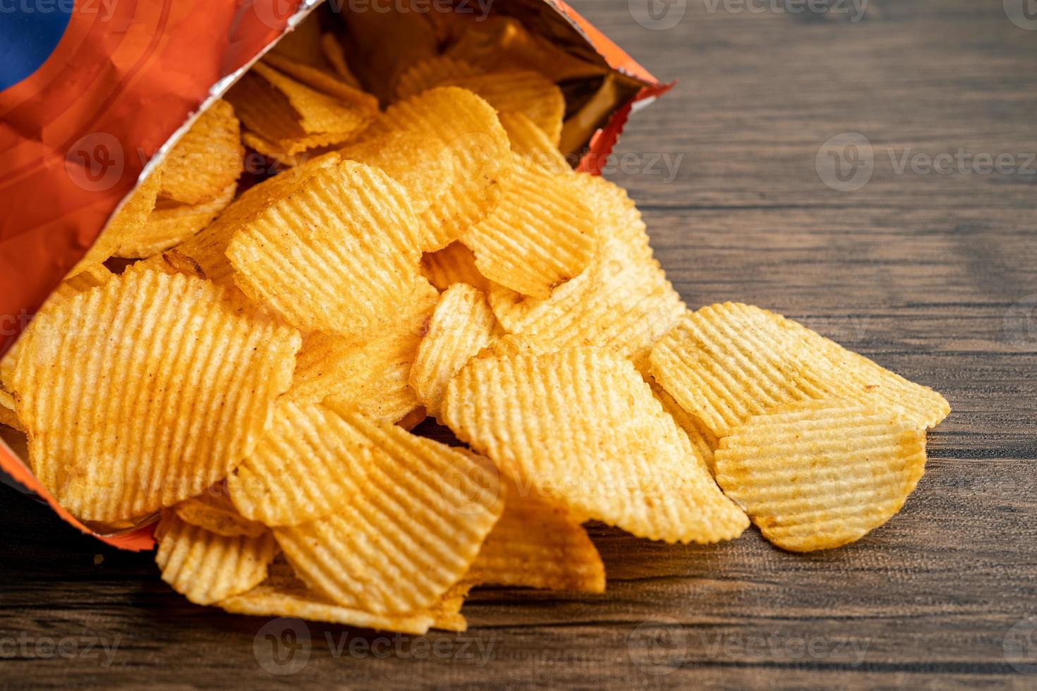 Potato chips, delicious BBQ seasoning spicy for crips, thin slice deep fried snack fast food in open bag. photo