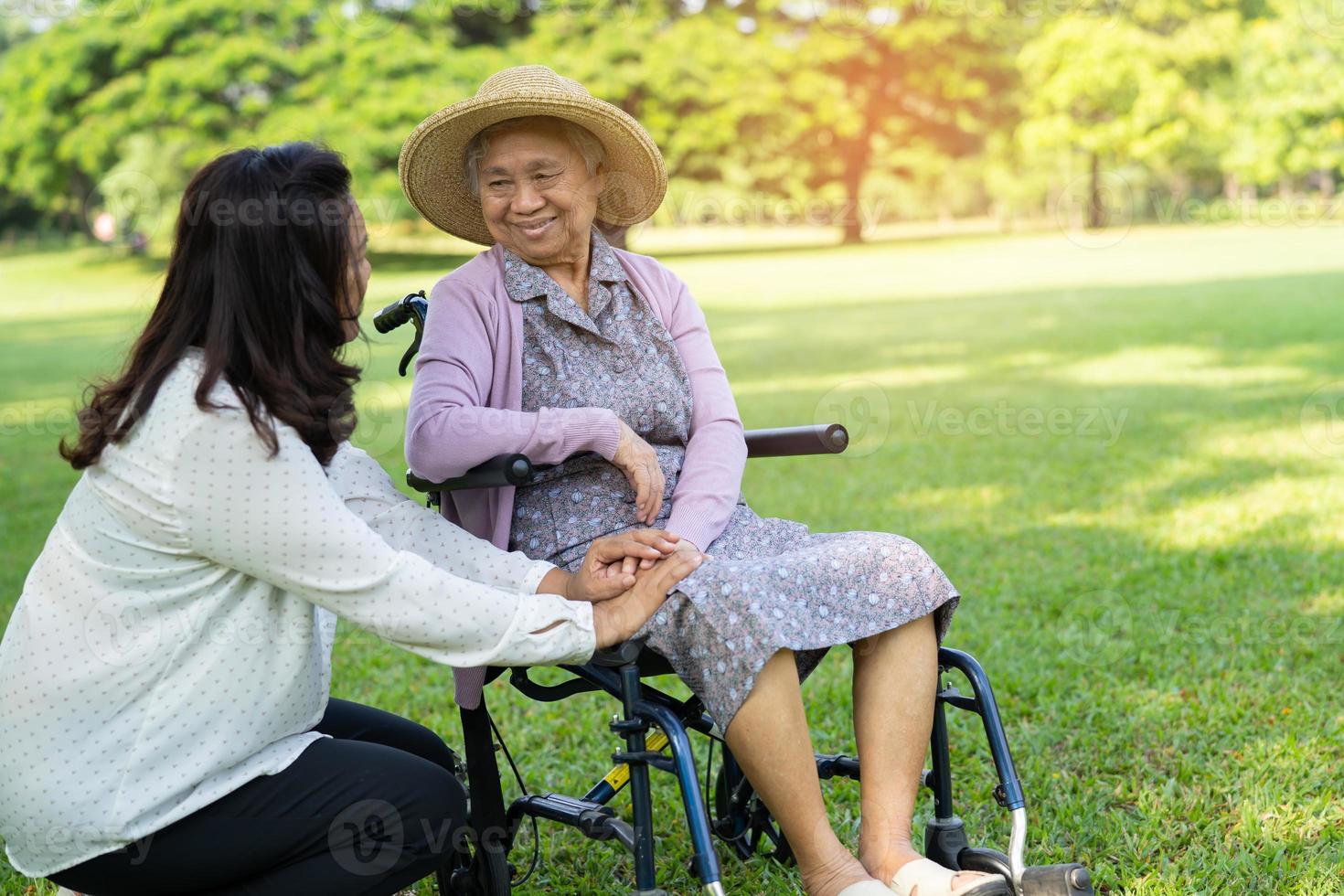 cuidador ayuda y cuidado asiático mayor mujer utilizar caminante con fuerte salud mientras caminando a parque en contento Fresco día festivo. foto