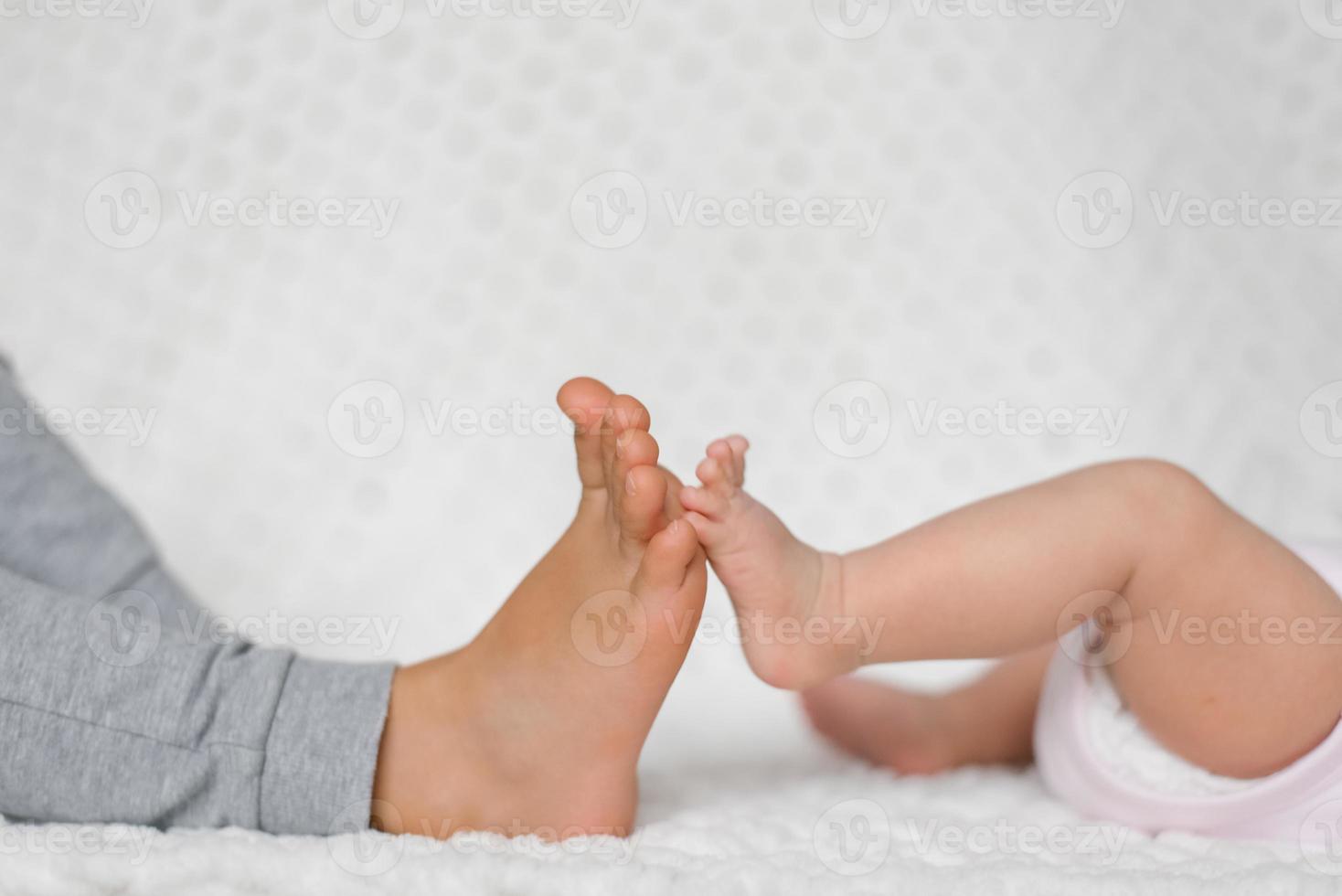 Close-up of the legs of two little brother and sister touching each other. Family relations child photo