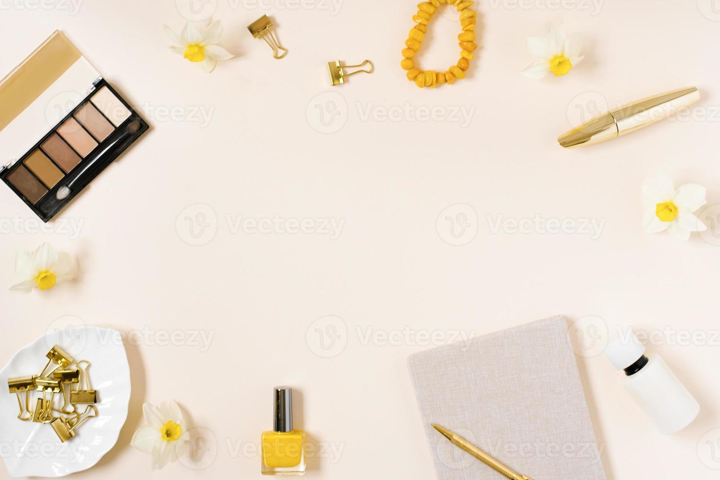 Workplace of a fashion blogger with a women's accessory, cosmetics on a pale beige table. Flat lay, top view photo