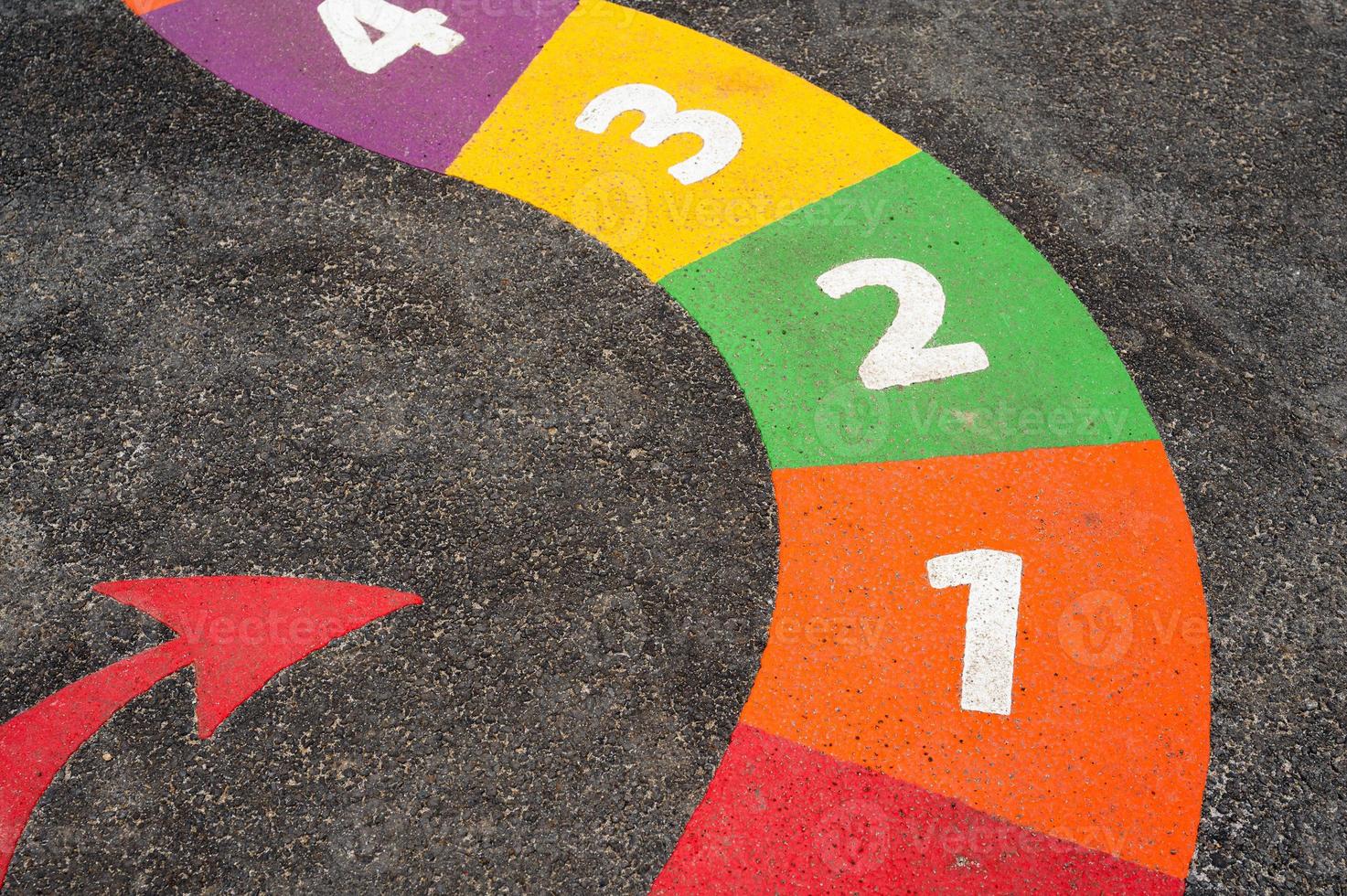 serpientes tablero juego con número en patio de recreo piso, brillante de colores pintar con número uno dos tres CUATRO con rojo flecha en pavimento ,al aire libre actividad para niños, aprendan y jugar para jardín de infancia colegio foto