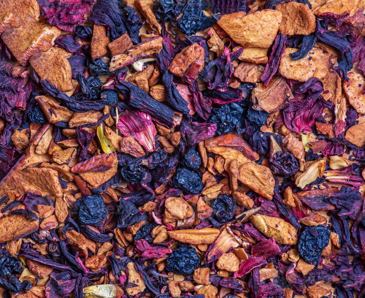 Background of natural fruit tea with hibiscus petals, fruit slices and berries. Fruit tea texture. Top view, flat lay. photo