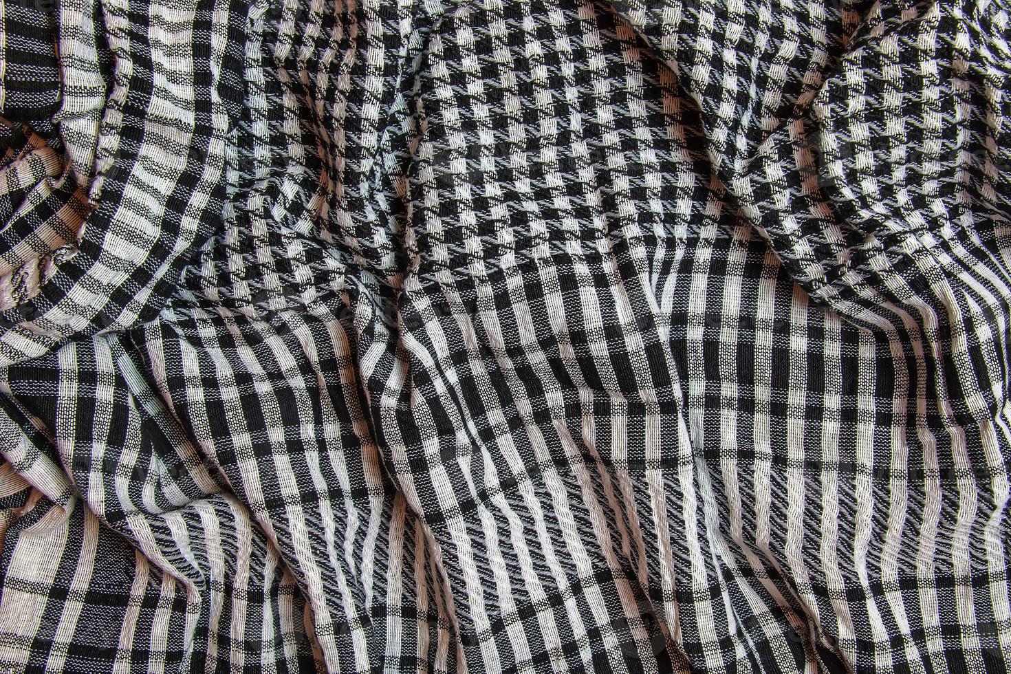 Background texture, pattern. Scarf wool like Yasser Arafat. The Palestinian keffiyeh is a gender-neutral checkered black and white scarf that is usually worn around the neck or head. photo