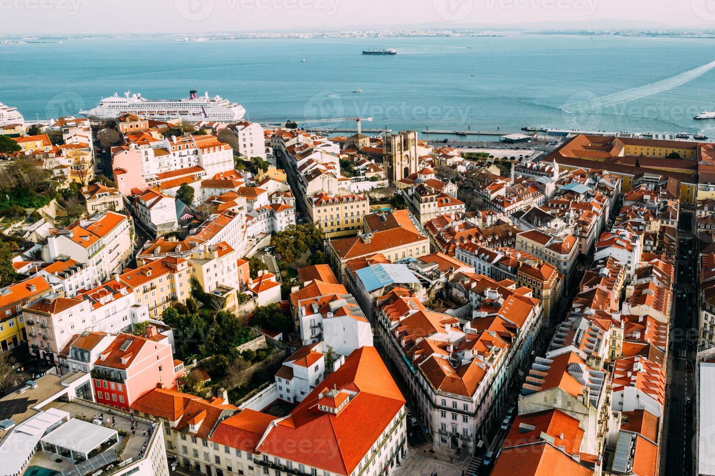 Aerial drone view of Baixa district in Lisbon, Portugal with surrounding major landmarks including Se Cathedral and cruise ship terminal on the Tagus photo