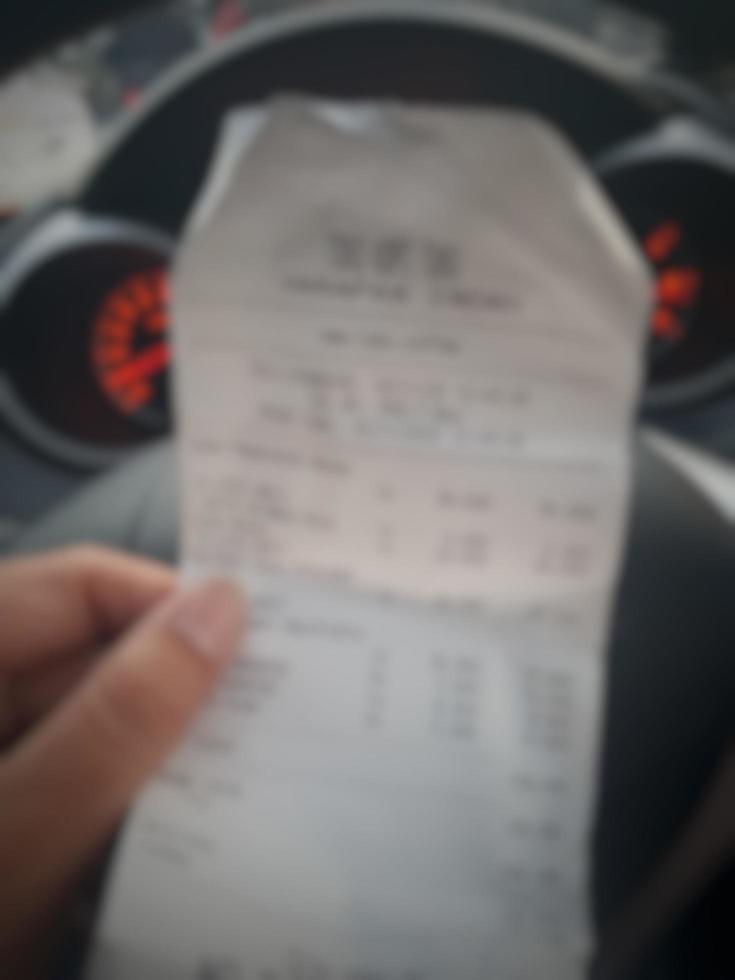 Defocused blurred photo of A hand is holding a shopping receipt