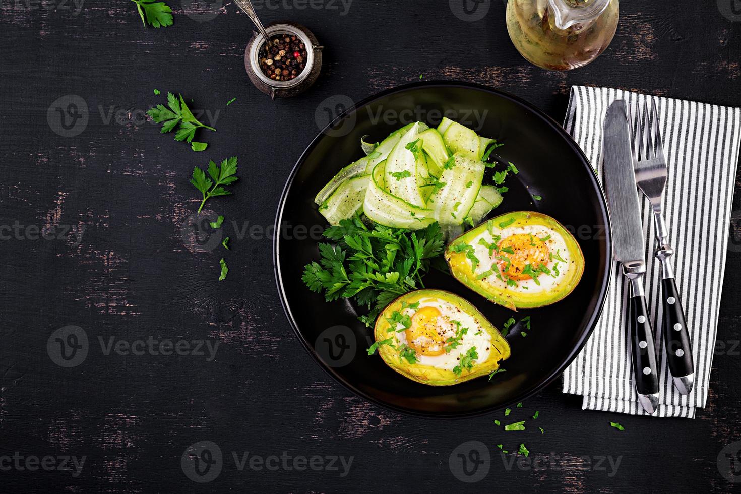 Avocado baked with egg and fresh salad. Vegetarian dish. Top view, overhead.  Ketogenic diet. Keto food photo