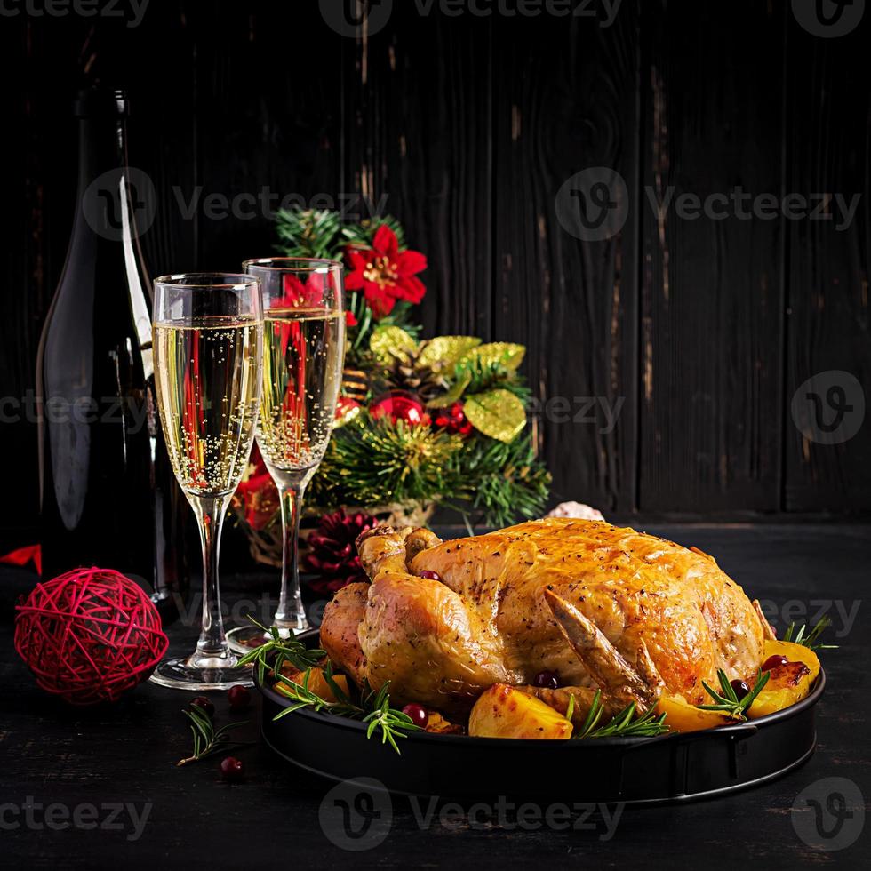Baked turkey or chicken. The Christmas table is served with a turkey, decorated with bright tinsel. Fried chicken. Table setting. Christmas dinner. photo