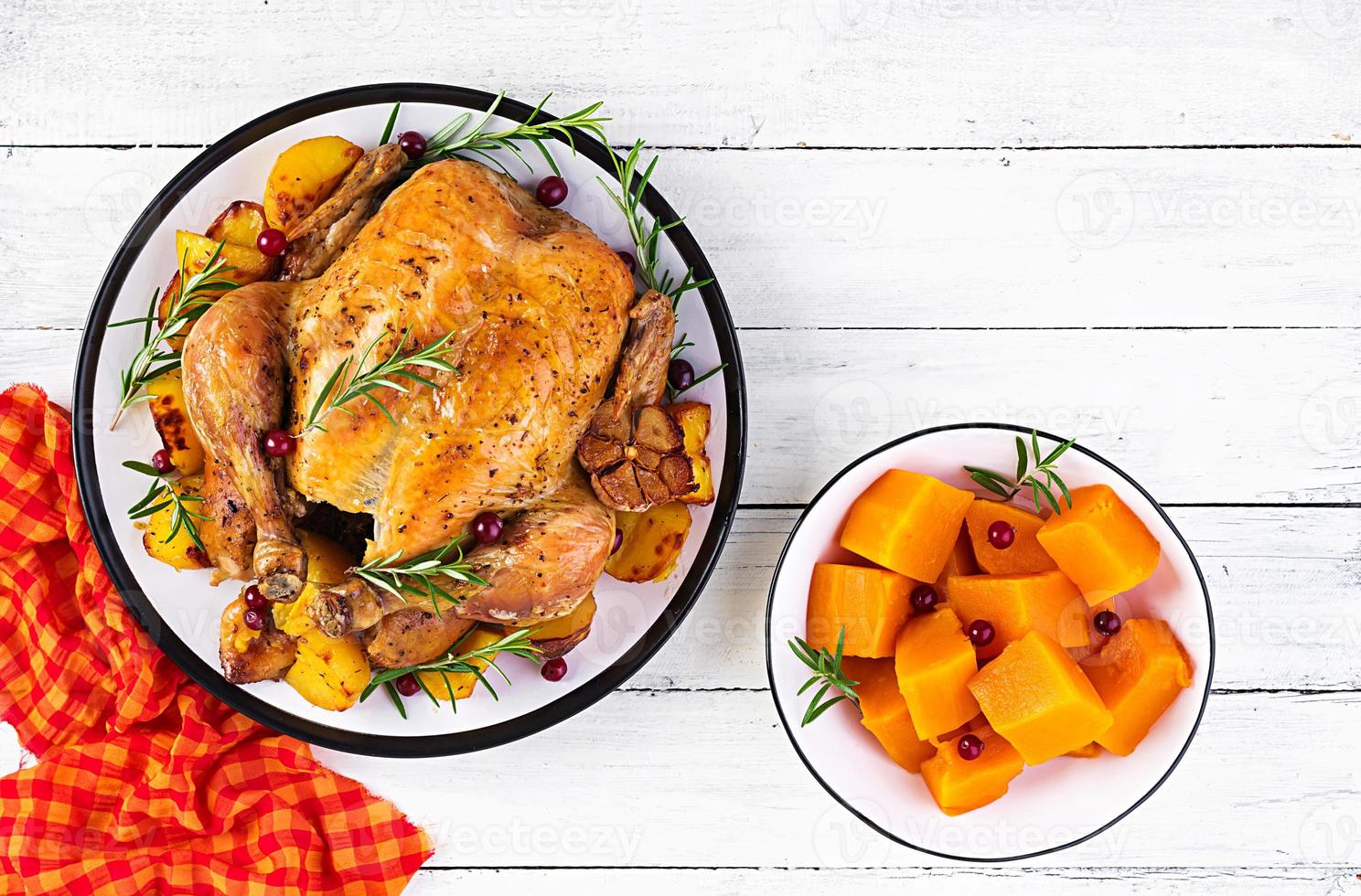 Roasted turkey garnished with cranberries on a rustic style table decorated  autumn leaf. Thanksgiving Day. Baked chicken. Top view photo