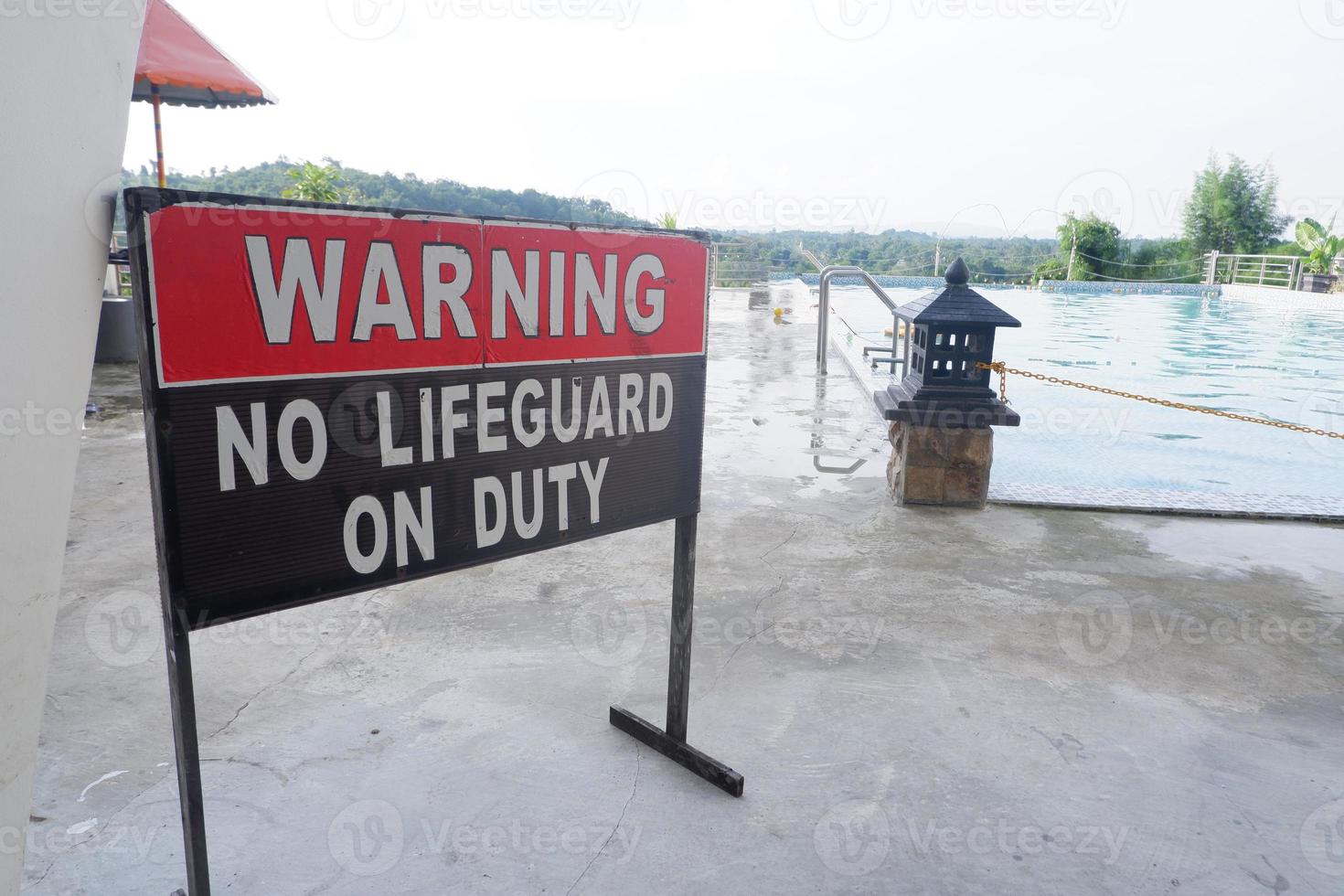 selective focus on the warning sign in the pool area that there are no lifeguards on duty, soft focus photo