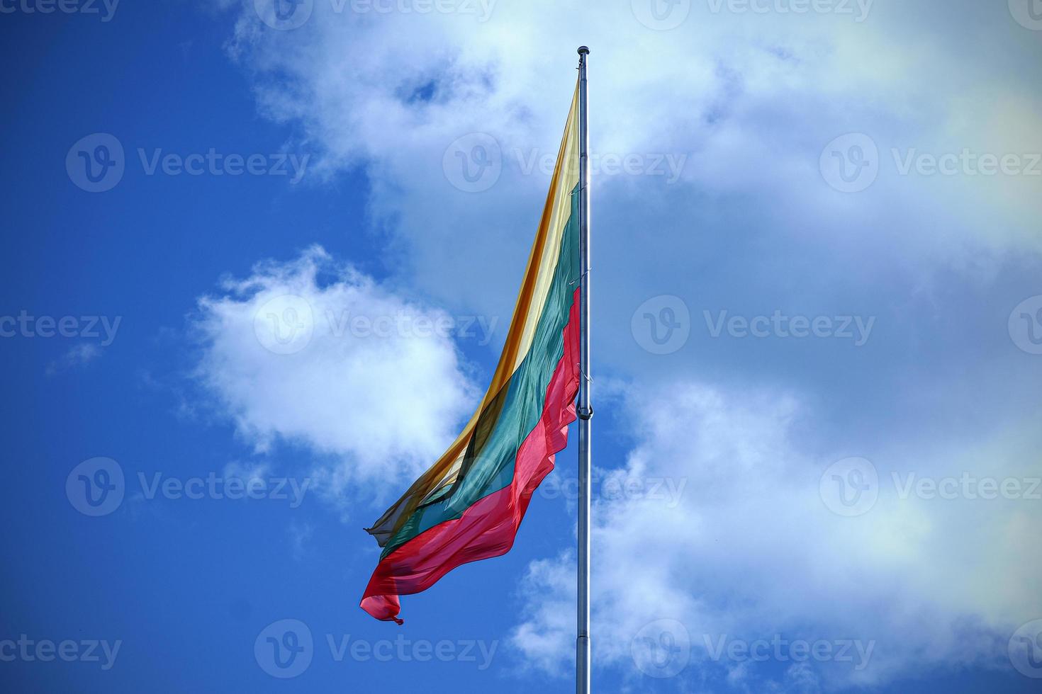 Flag of Lithuania on blue sky with clouds background photo