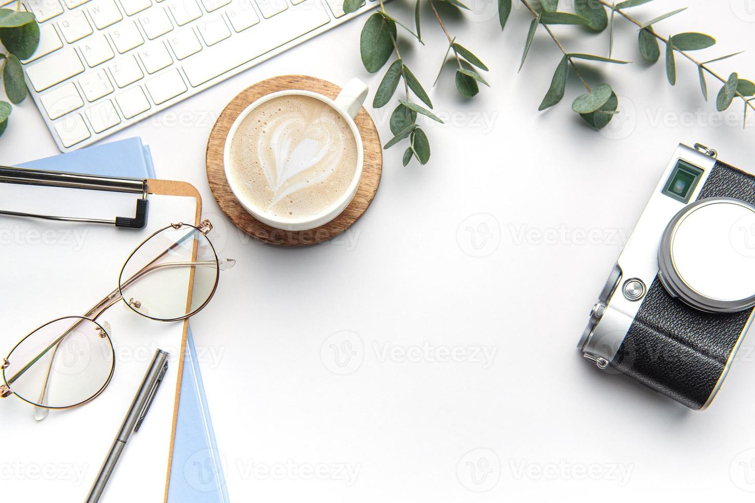 moderno blanco oficina escritorio mesa con computadora portátil, cámara, cuaderno y otro suministros. foto