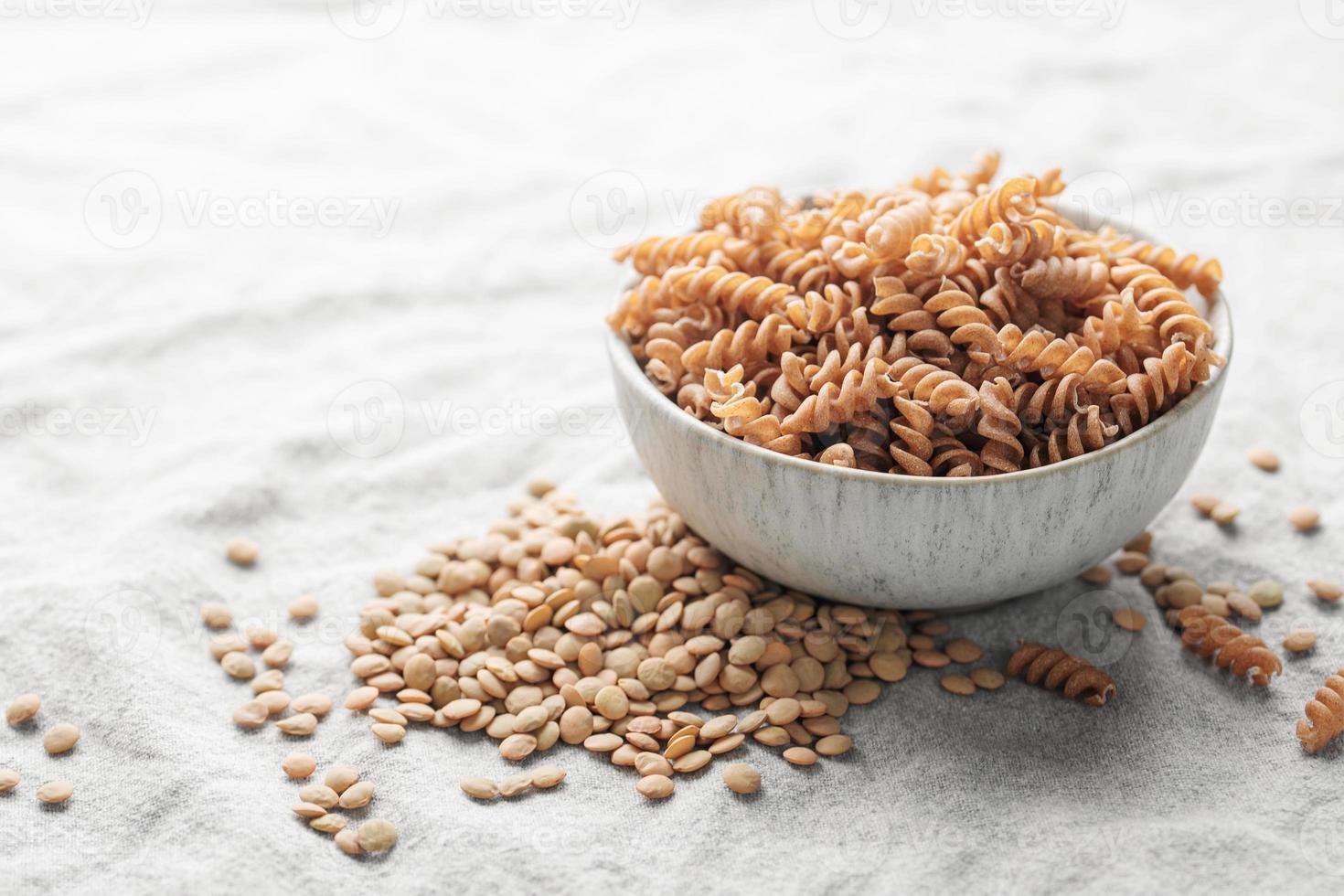 Green lentil fusilli pasta on a gray textile background. photo